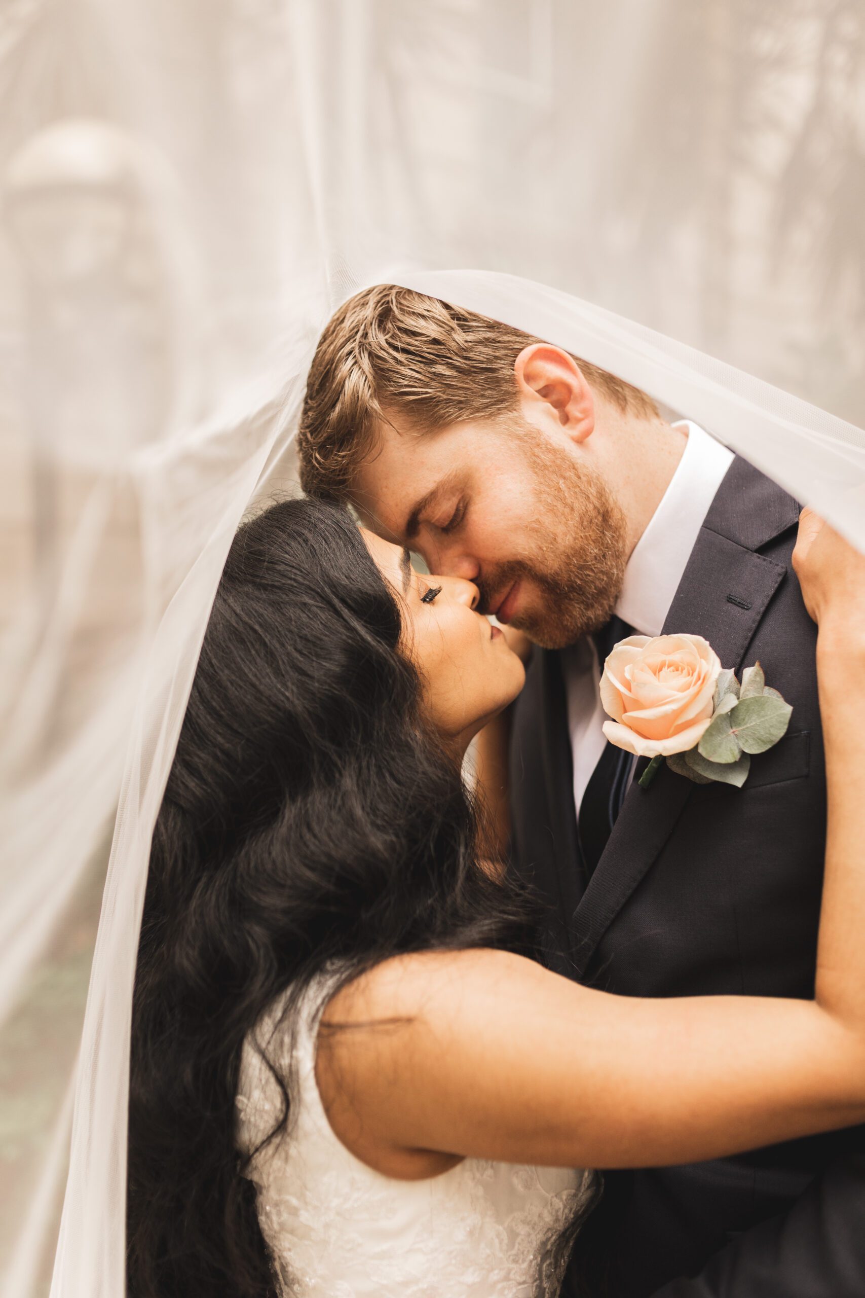 Bride and groom kiss under veil at Bristol hotel wedding