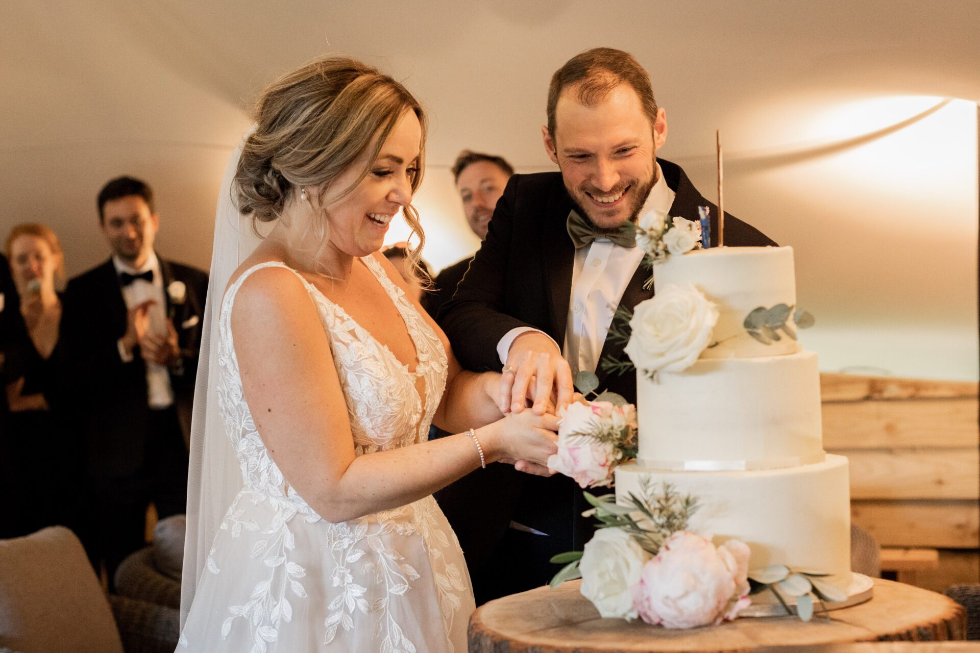 The bride and groom cut their cake at Old Luxters Barn wedding venue in Oxfordshire