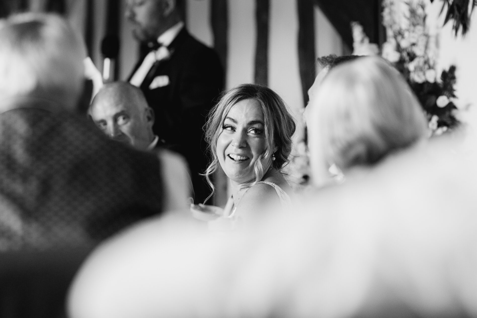 The bride listens to speeches at Old Luxters Barn wedding venue in Oxfordshire