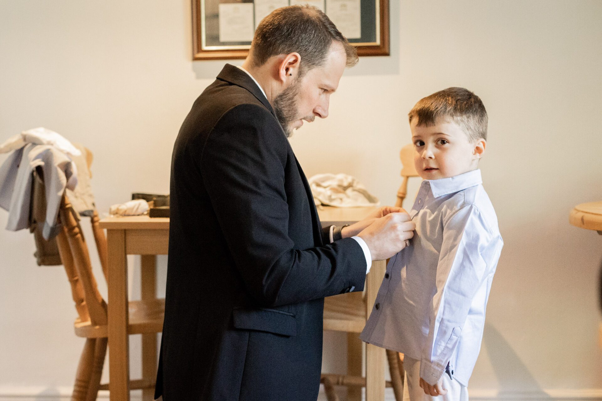The groom helps his son get ready for the wedding