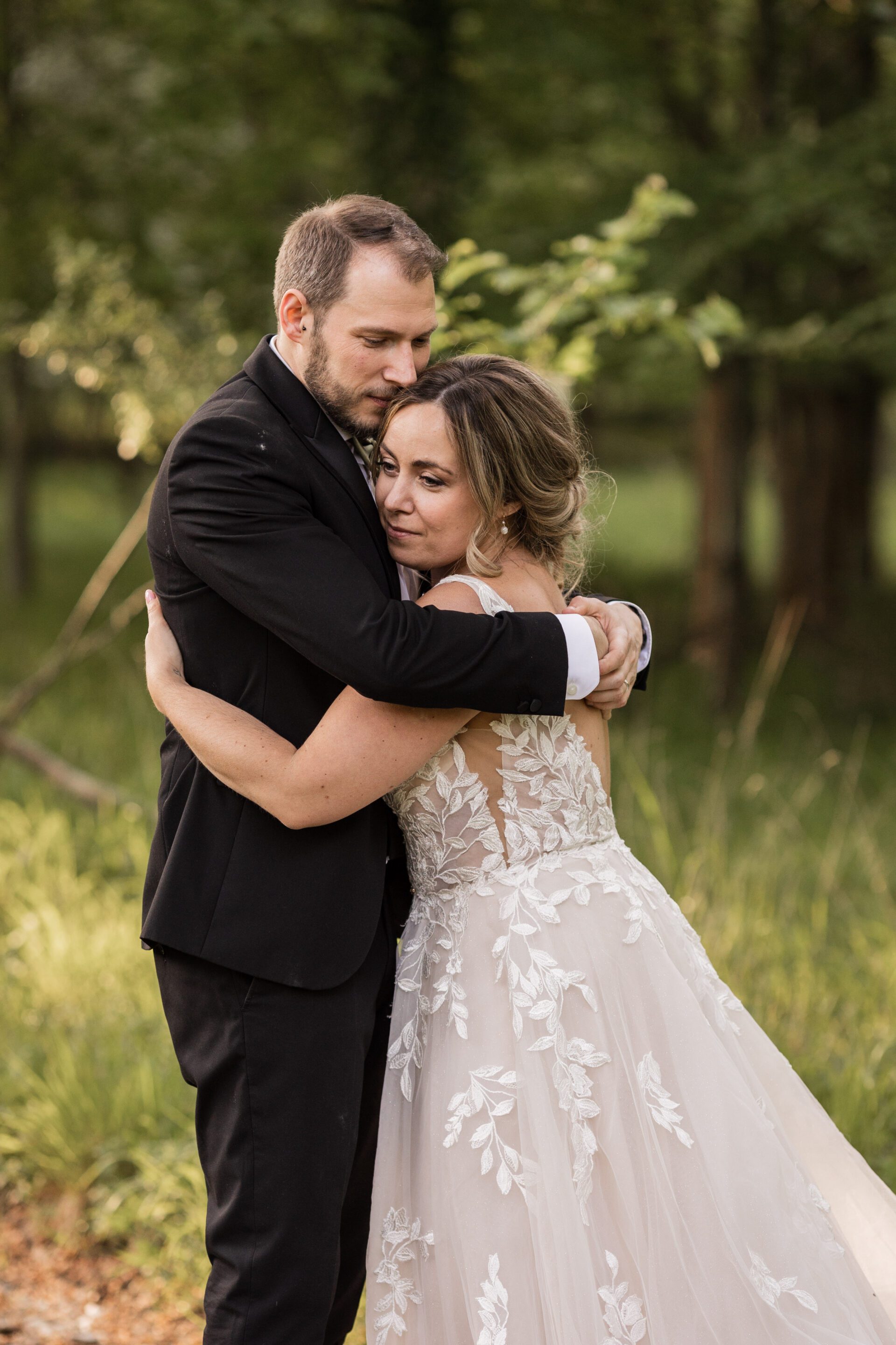 The bride and groom share an embrace during their barn wedding