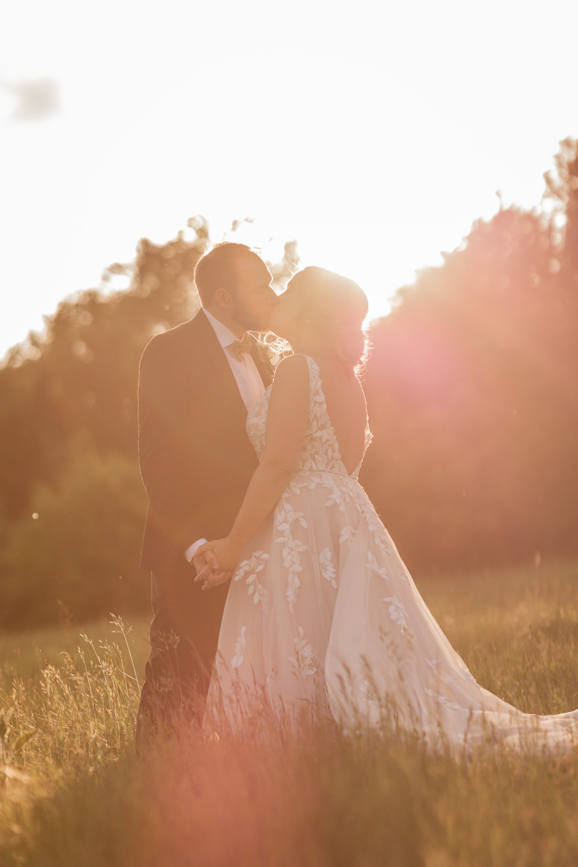 The bride and groom share a kiss in gorgeous golden hour light