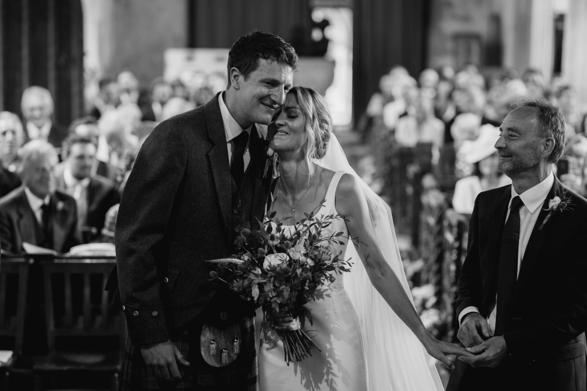 The bride and groom share an emotional embrace at the end of the aisle of this Devon church wedding ceremony