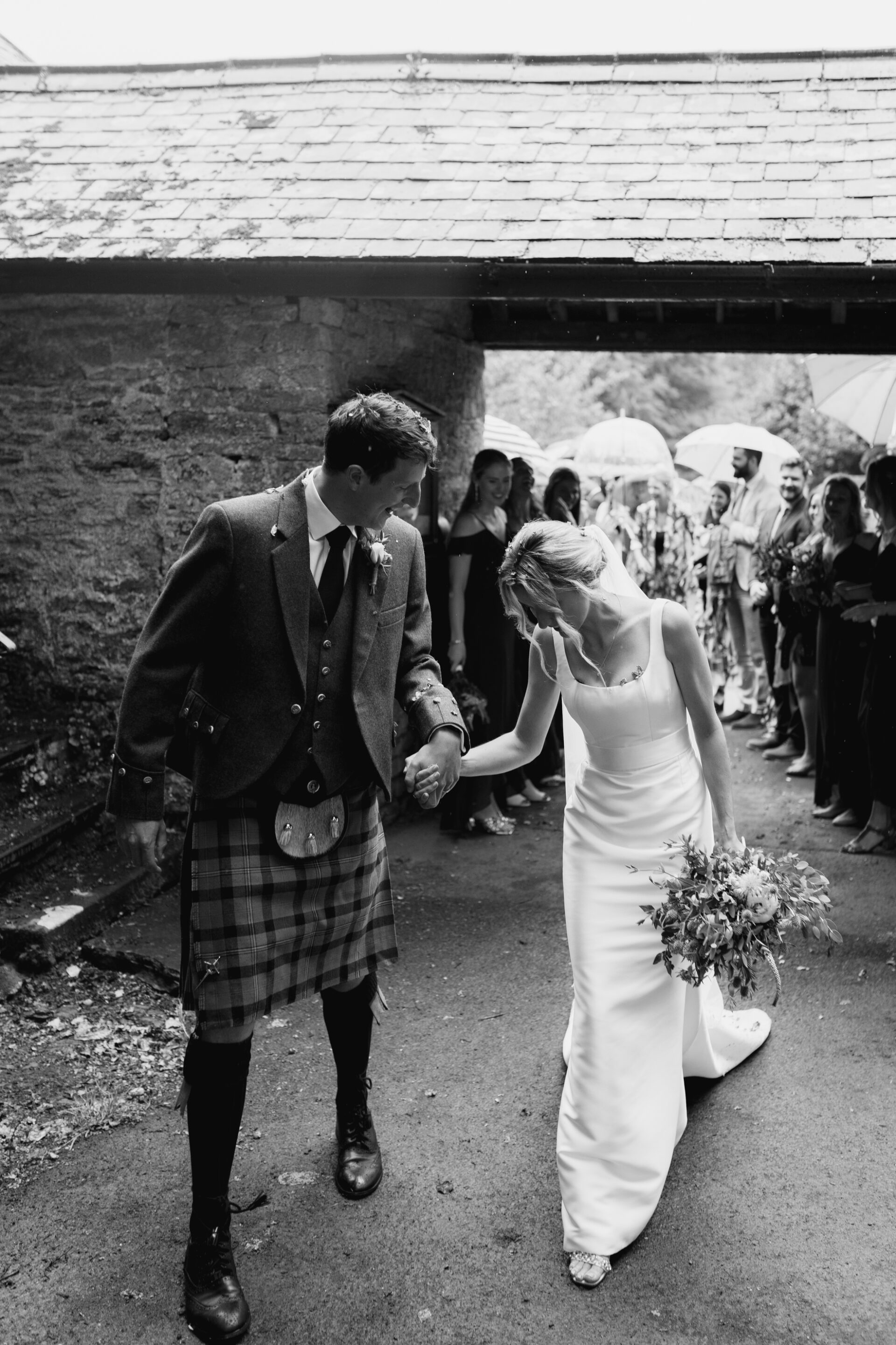 The bride and groom leave their Devon church wedding ceremony