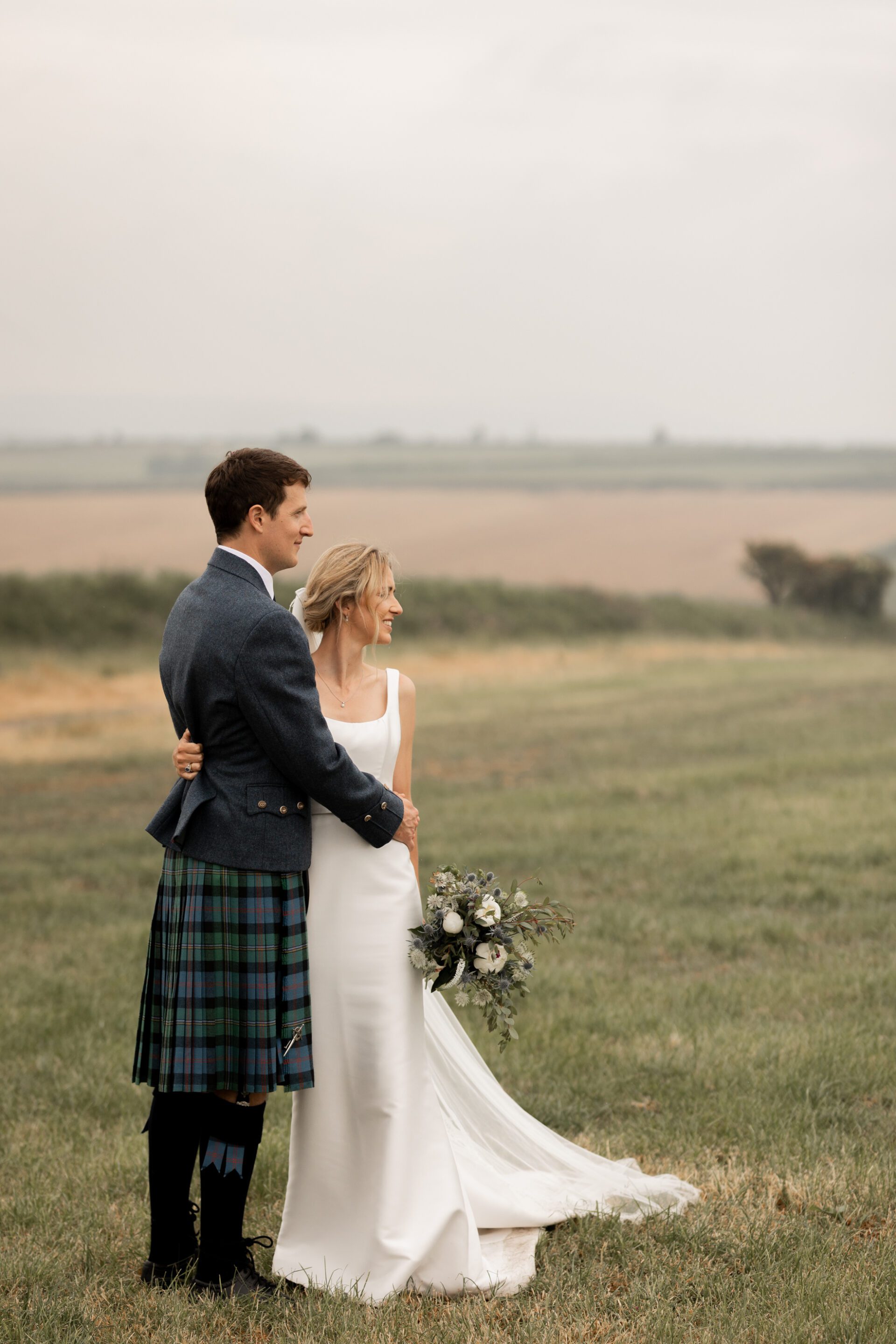 The bride and groom look off into the distance during their couples portrait session