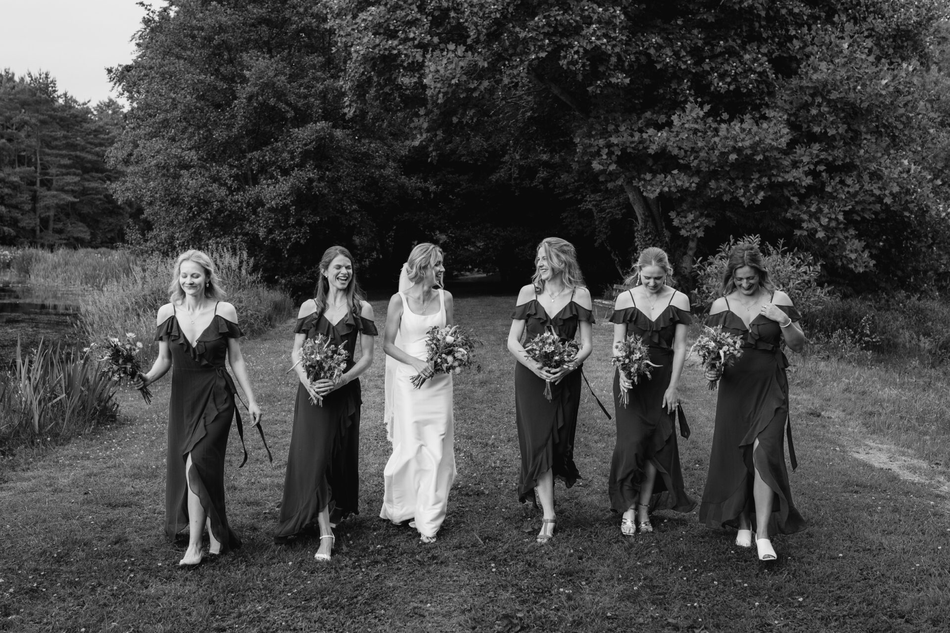 The bride walks with her bridesmaids at the outdoor wedding reception
