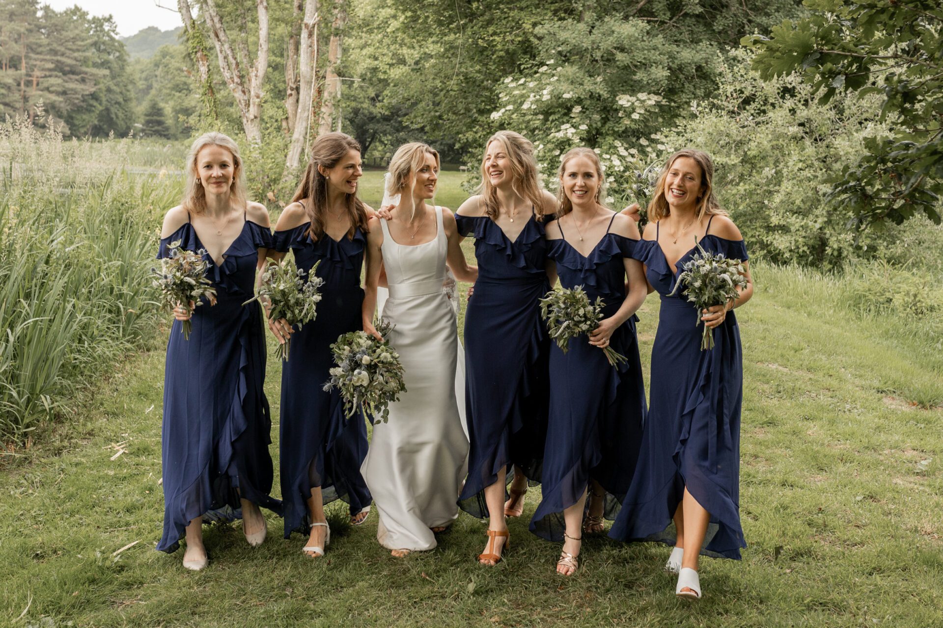 The bride shares a laugh with her bridesmaids at her Devon marquee wedding