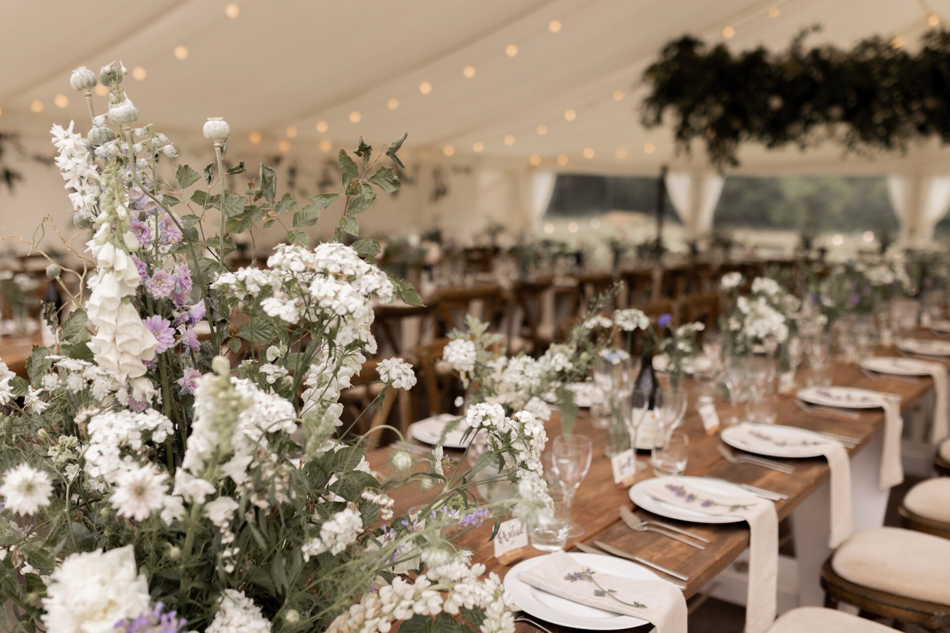 An abundance of local flowers decorate this Devon marquee wedding