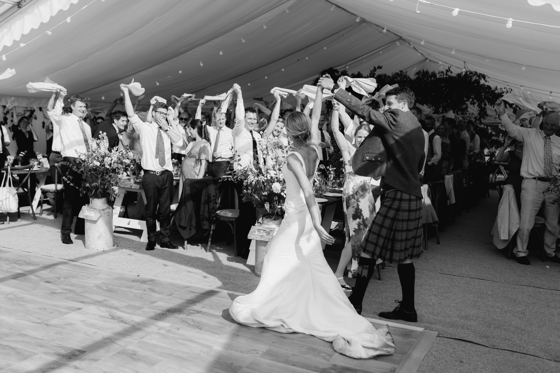 The bride and groom arrive to cheers from the guests for the wedding breakfast at their Devon marquee wedding