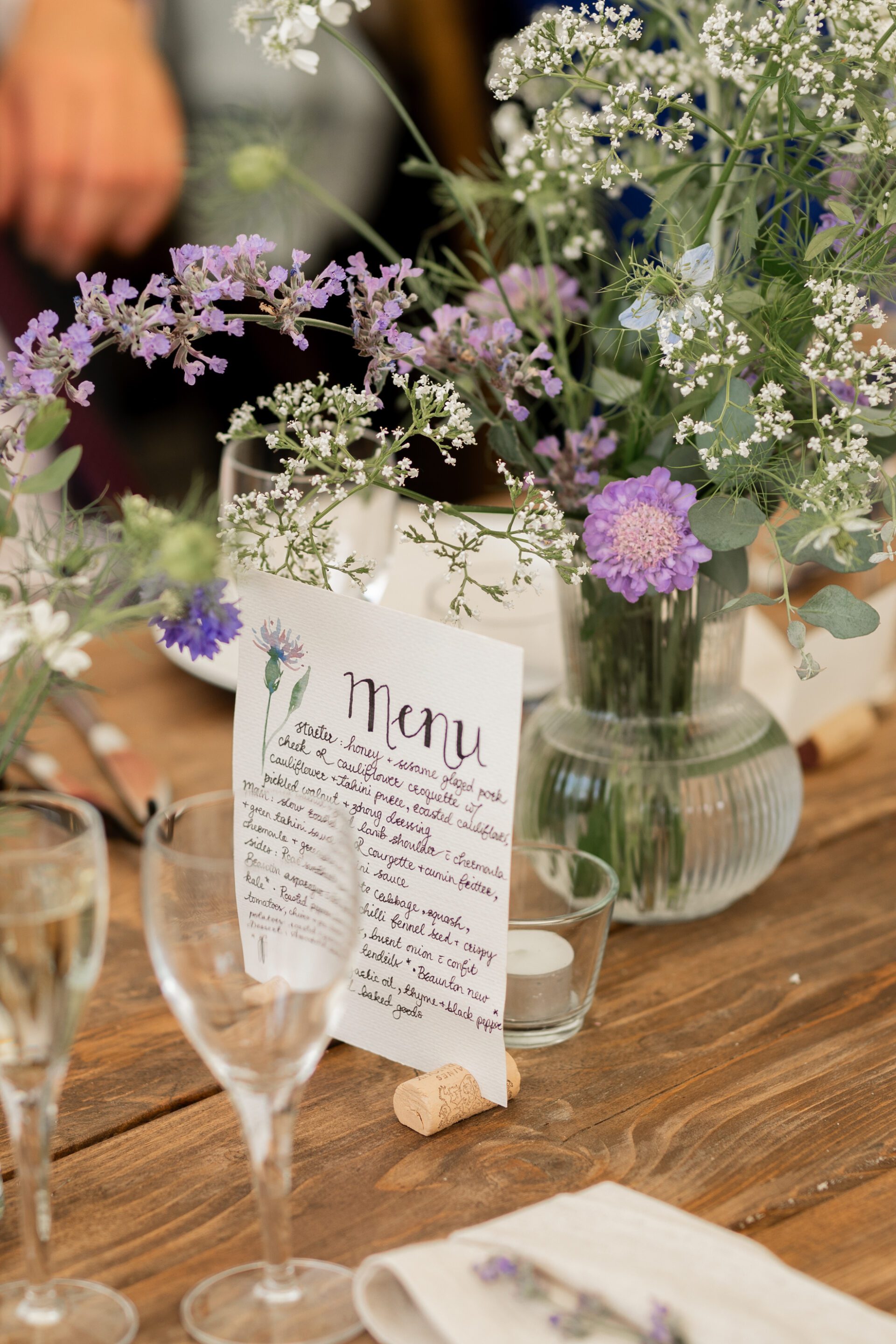 A beautiful handwritten menu adorns the table at a Devon marquee wedding