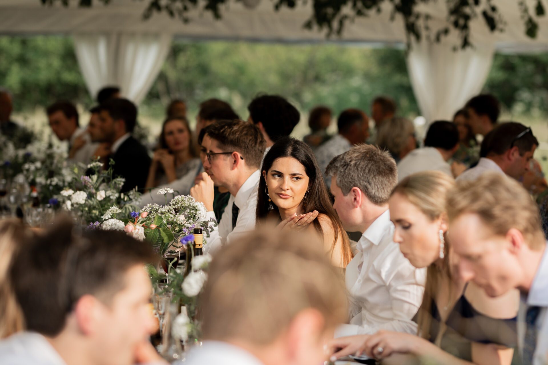 Wedding guests converse during the wedding breakfast at a Devon marquee wedding