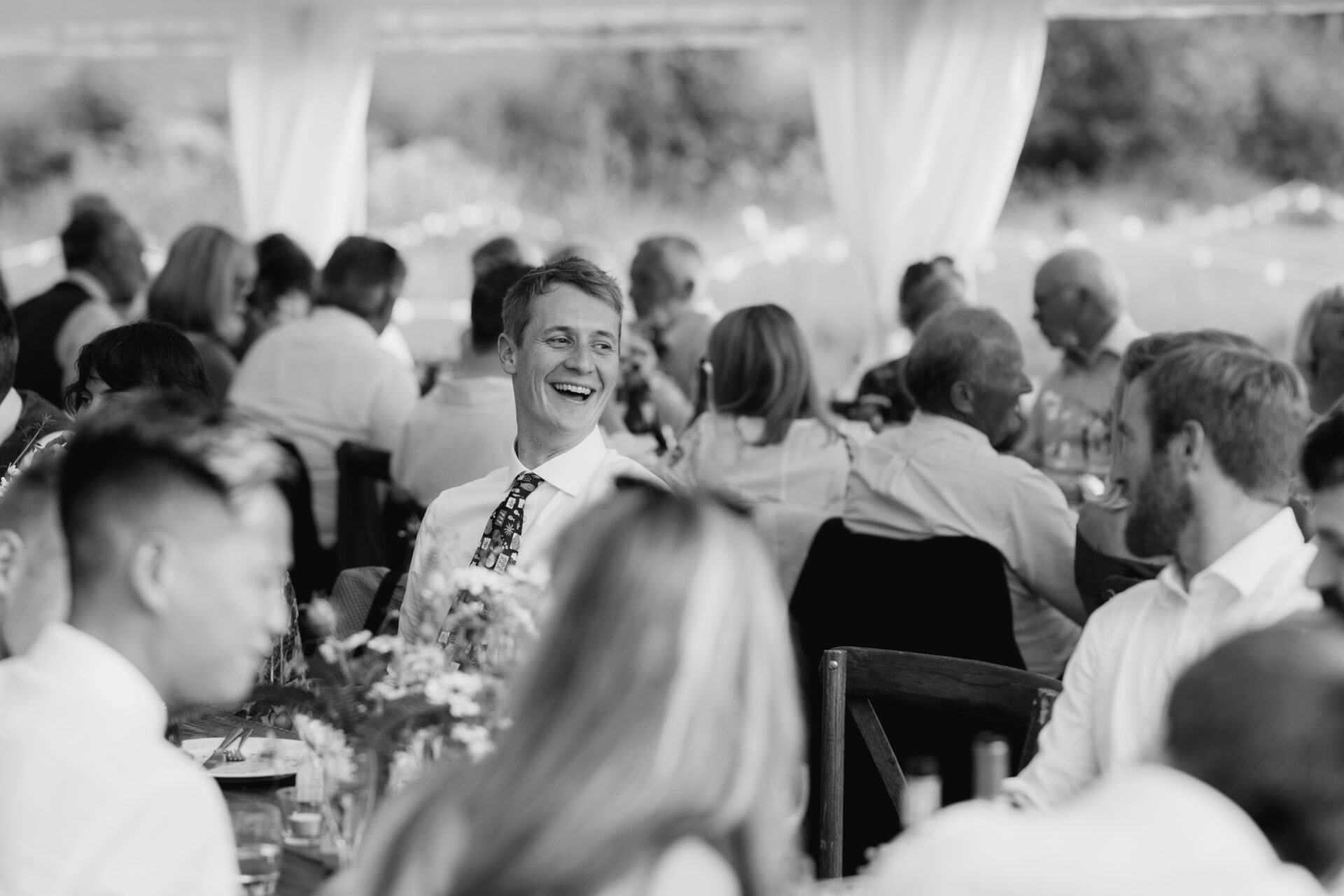 Wedding guests share a laugh during the wedding breakfast