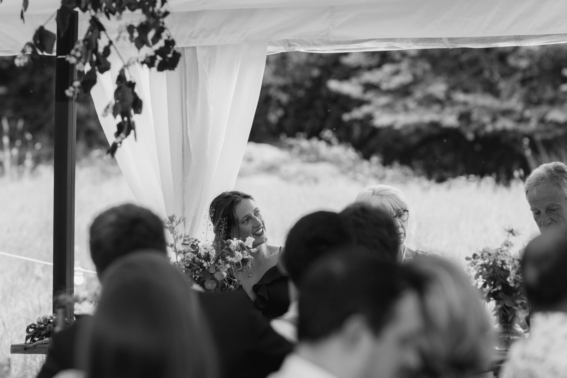 A wedding guest listens to the speeches at a Devon marquee wedding