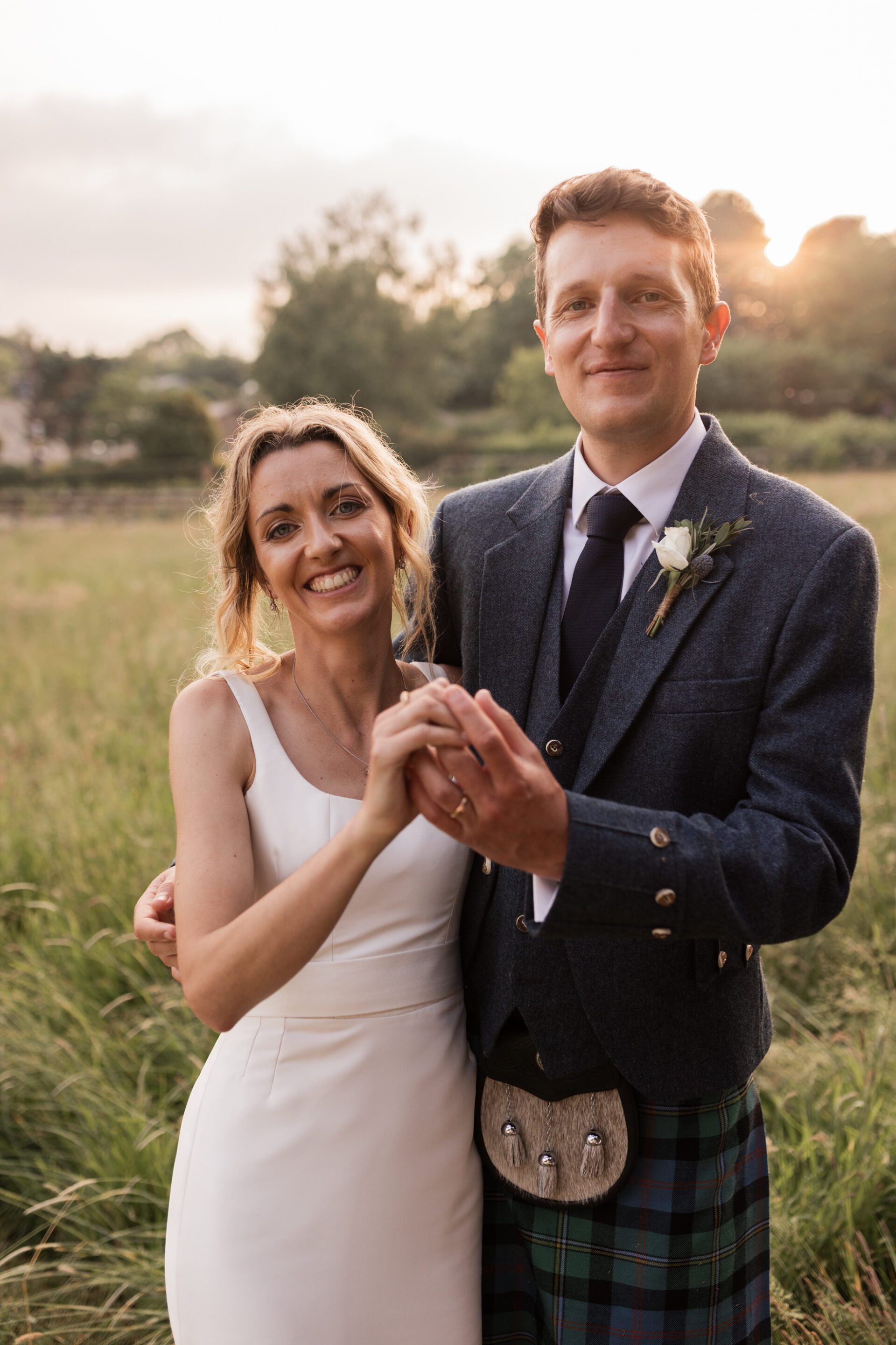 The bride and groom pose for golden hour portraits at their Devon marquee wedding