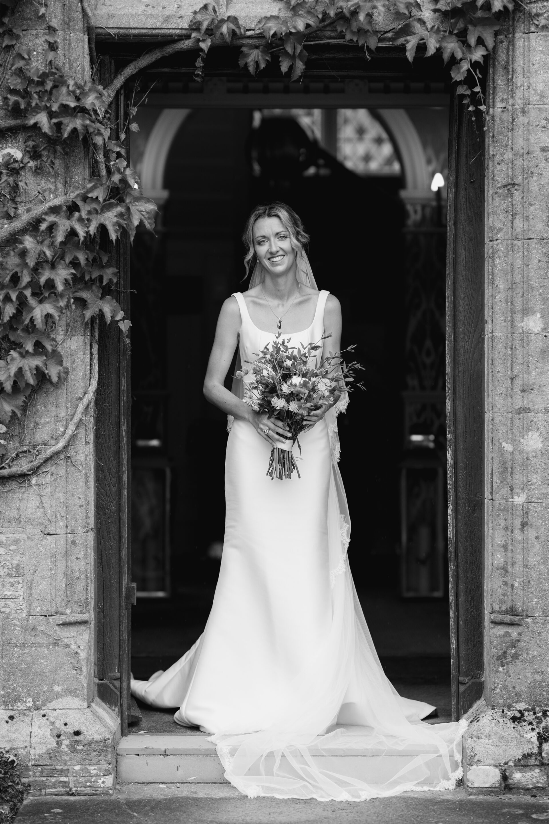 The bride stops for a portrait in the doorway of the family home