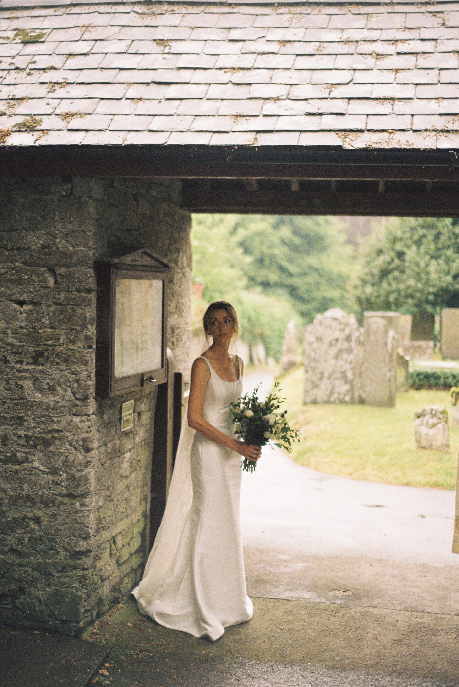 The bride is captured on 35mm film before the Devon church wedding ceremony