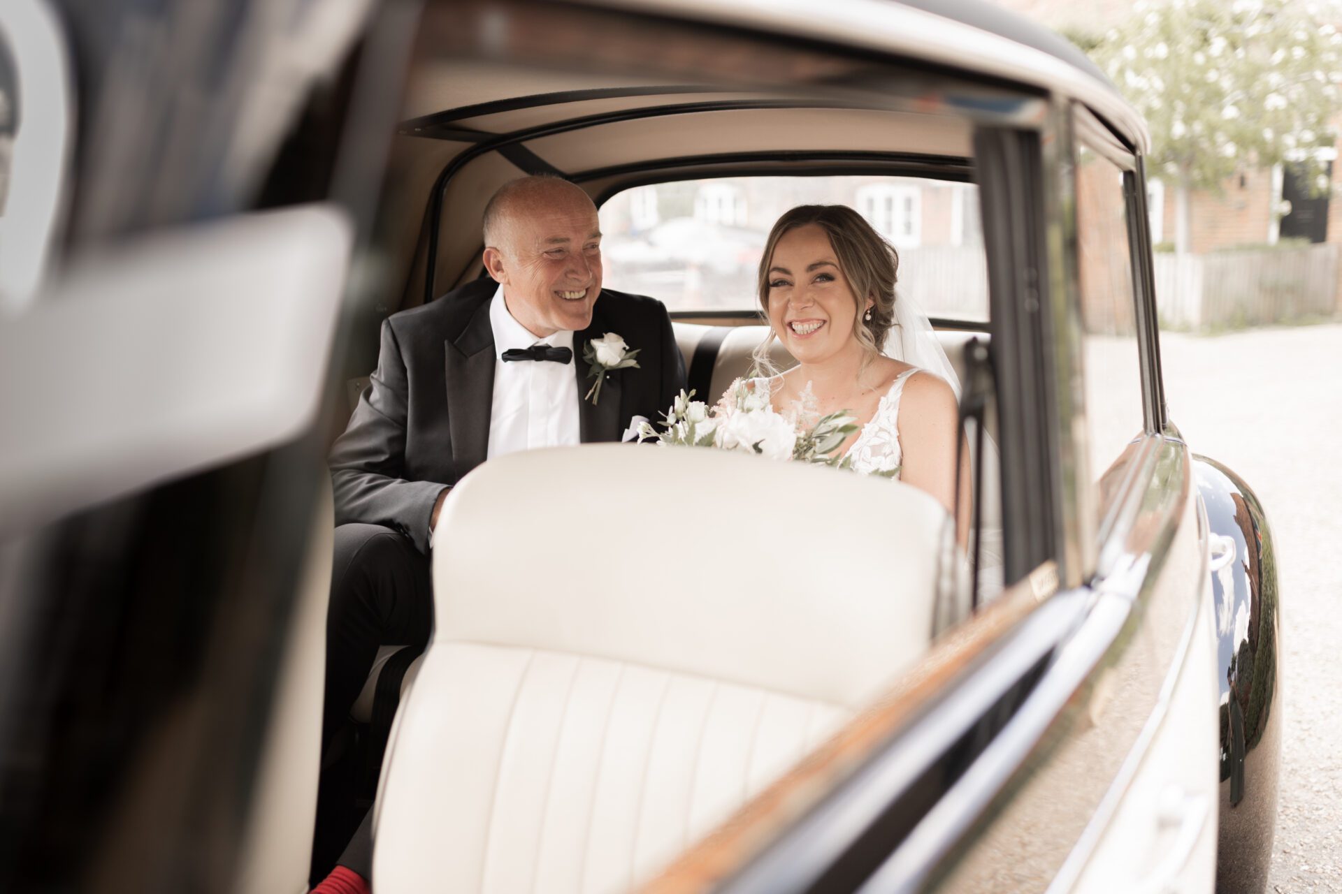 The bride and her father arrive at the church wedding ceremony in a vintage wedding car
