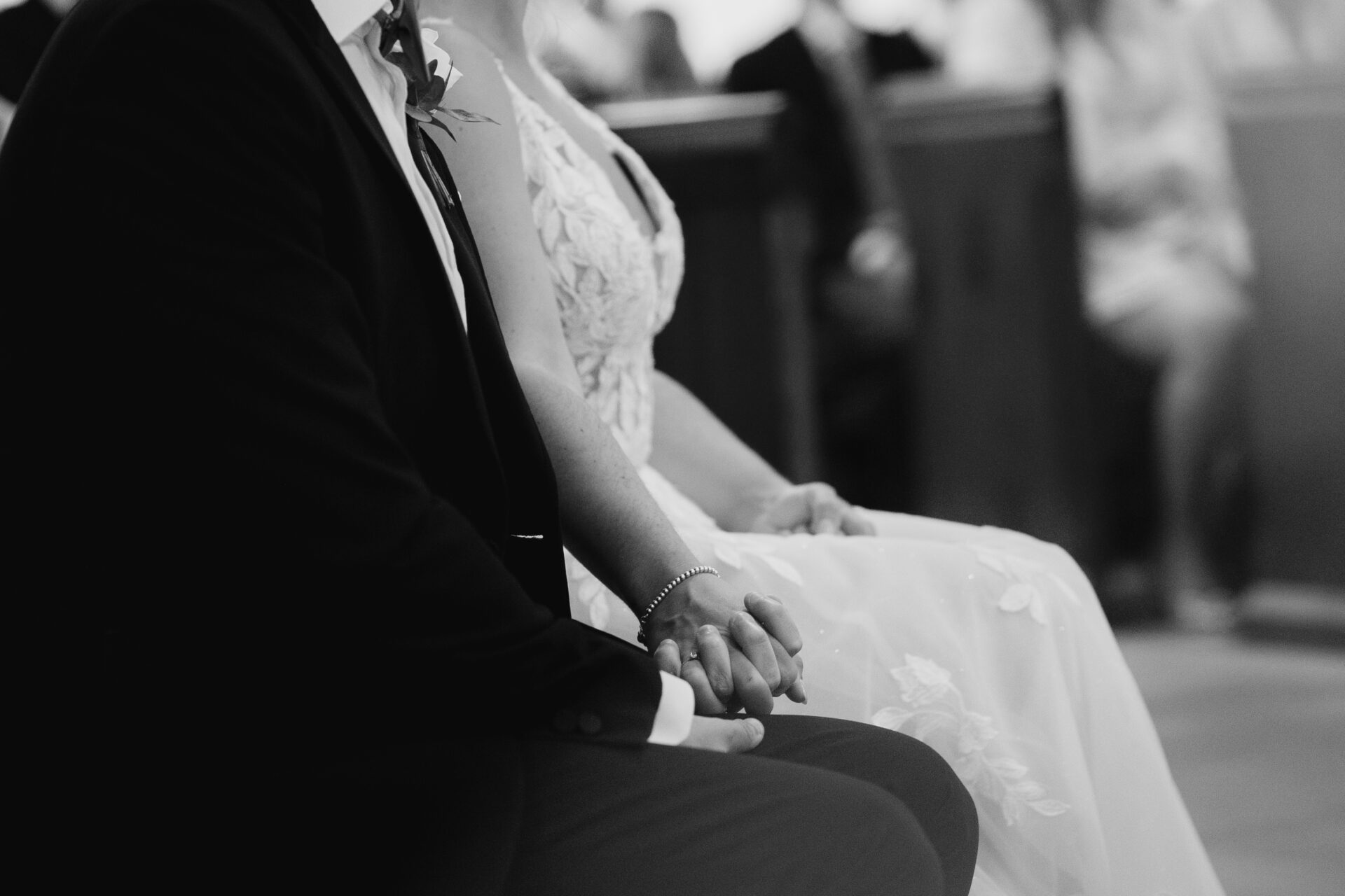 The bride and groom hold hands during the wedding ceremony