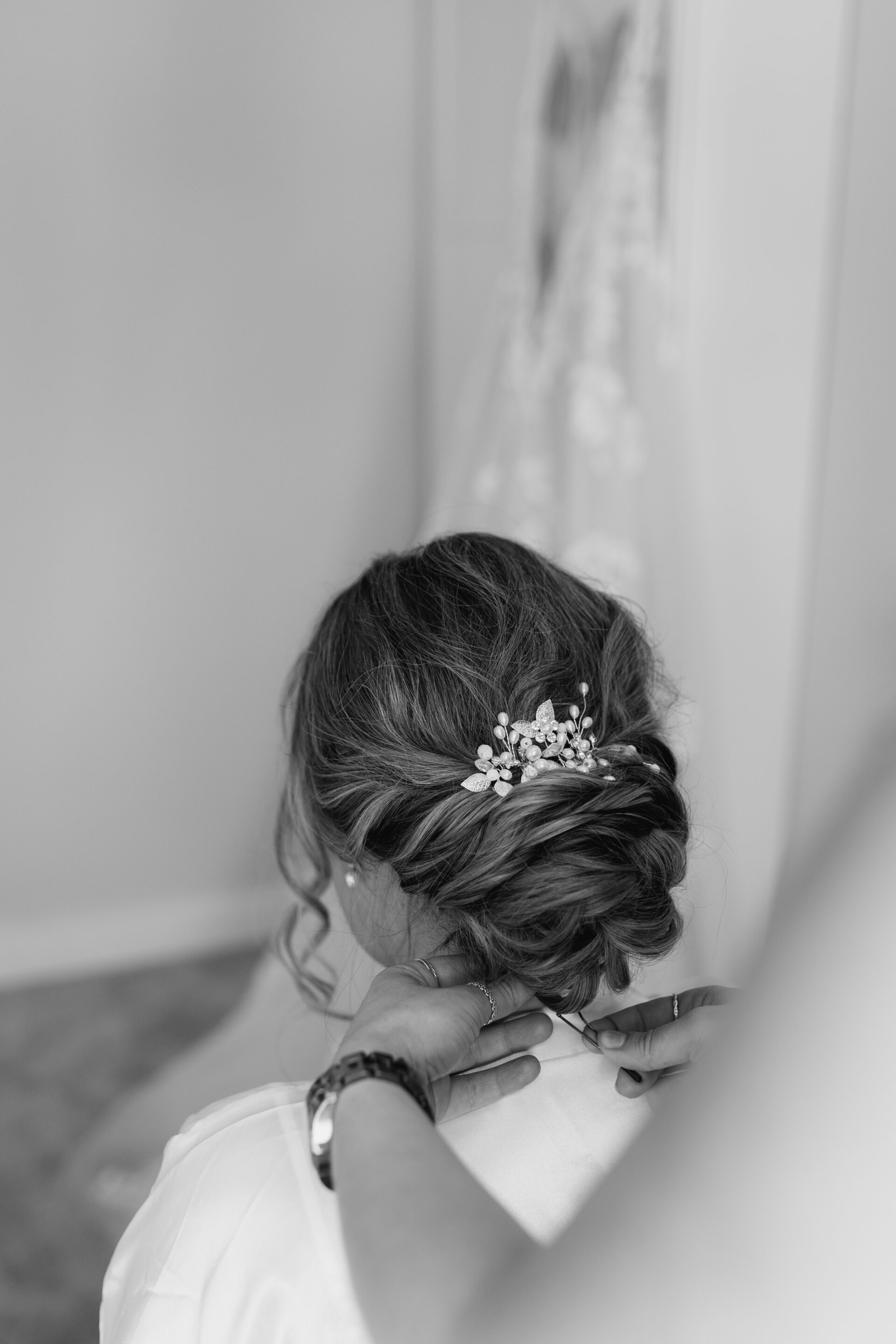 Finishing touches are made to the bride's elegant bridal hair up do