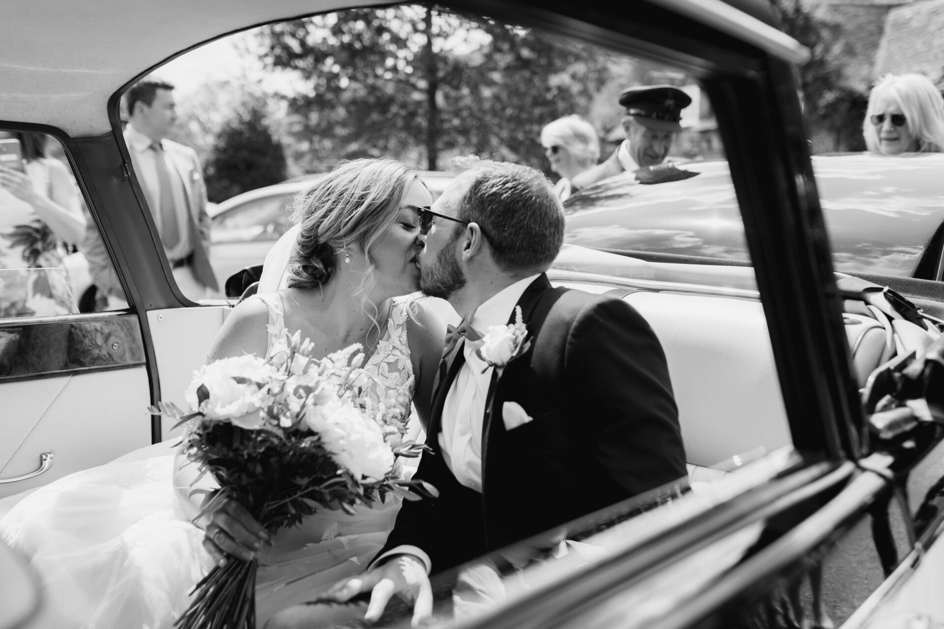 The bride and groom share a kiss as they leave their church wedding ceremony