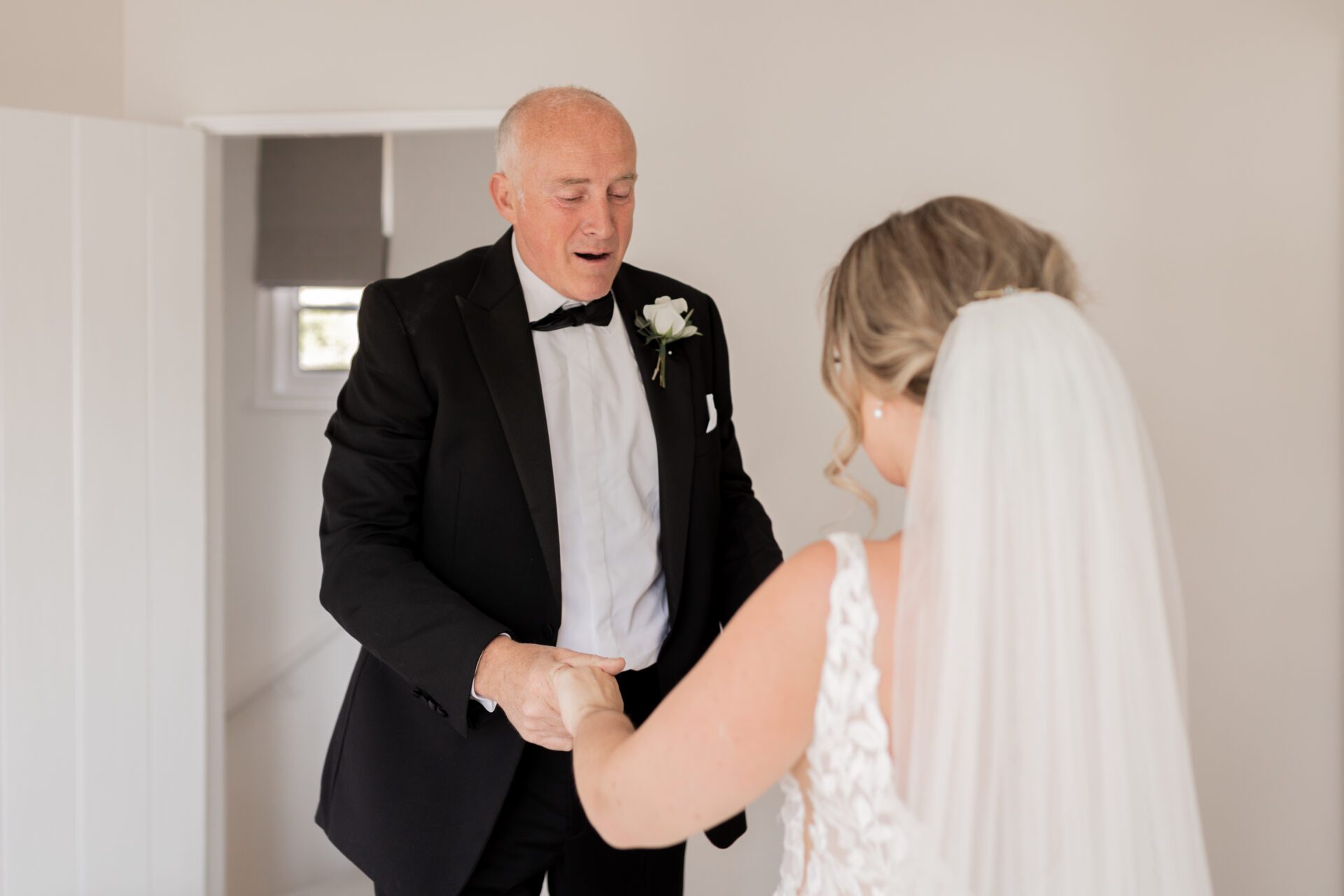 The father of the bride is overcome with emotion as he sees the bride for the first time
