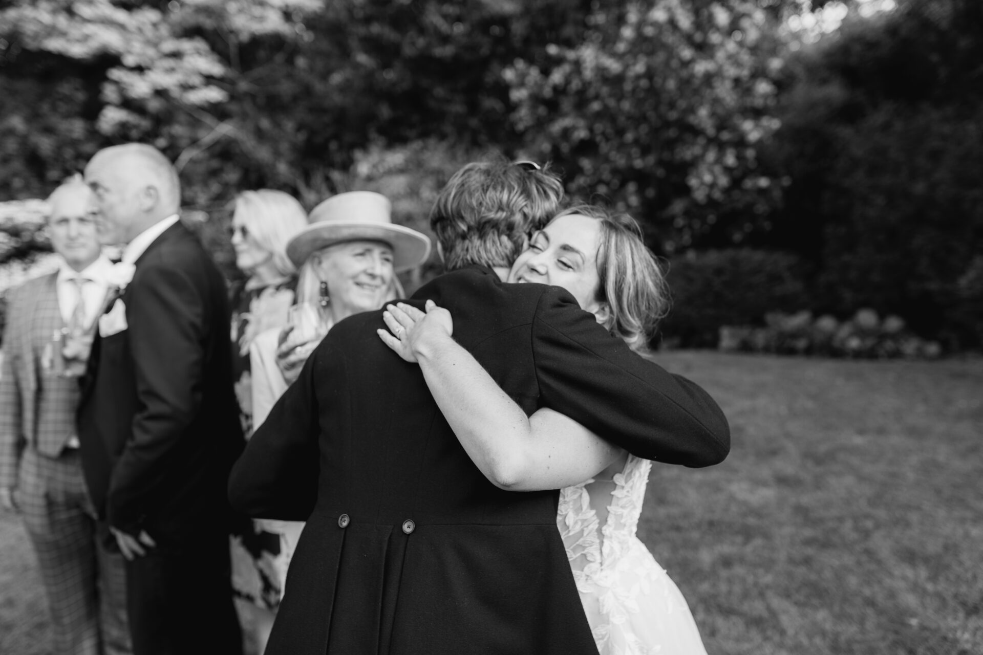 The bride embraces a wedding guest at Old Luxters Barn wedding venue in Oxfordshire