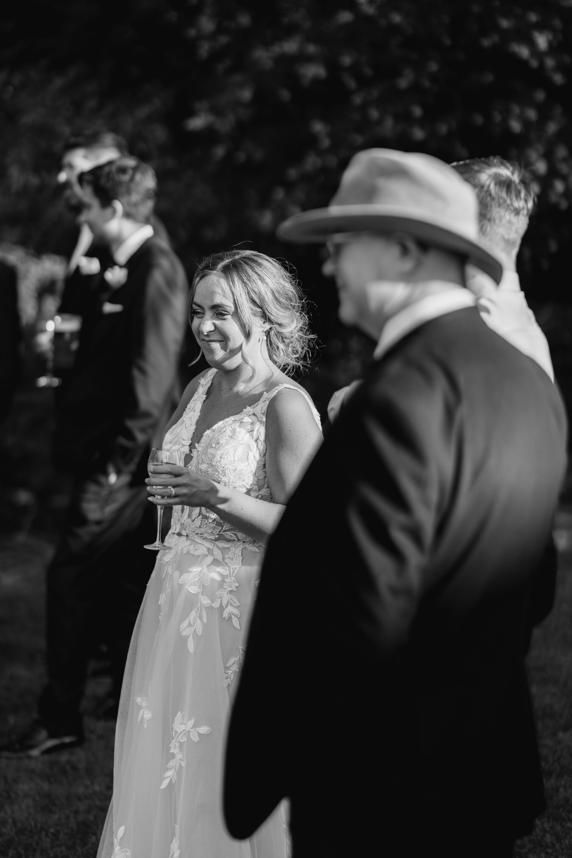 The bride talks with wedding guests at Old Luxters Barn wedding venue in Oxfordshire