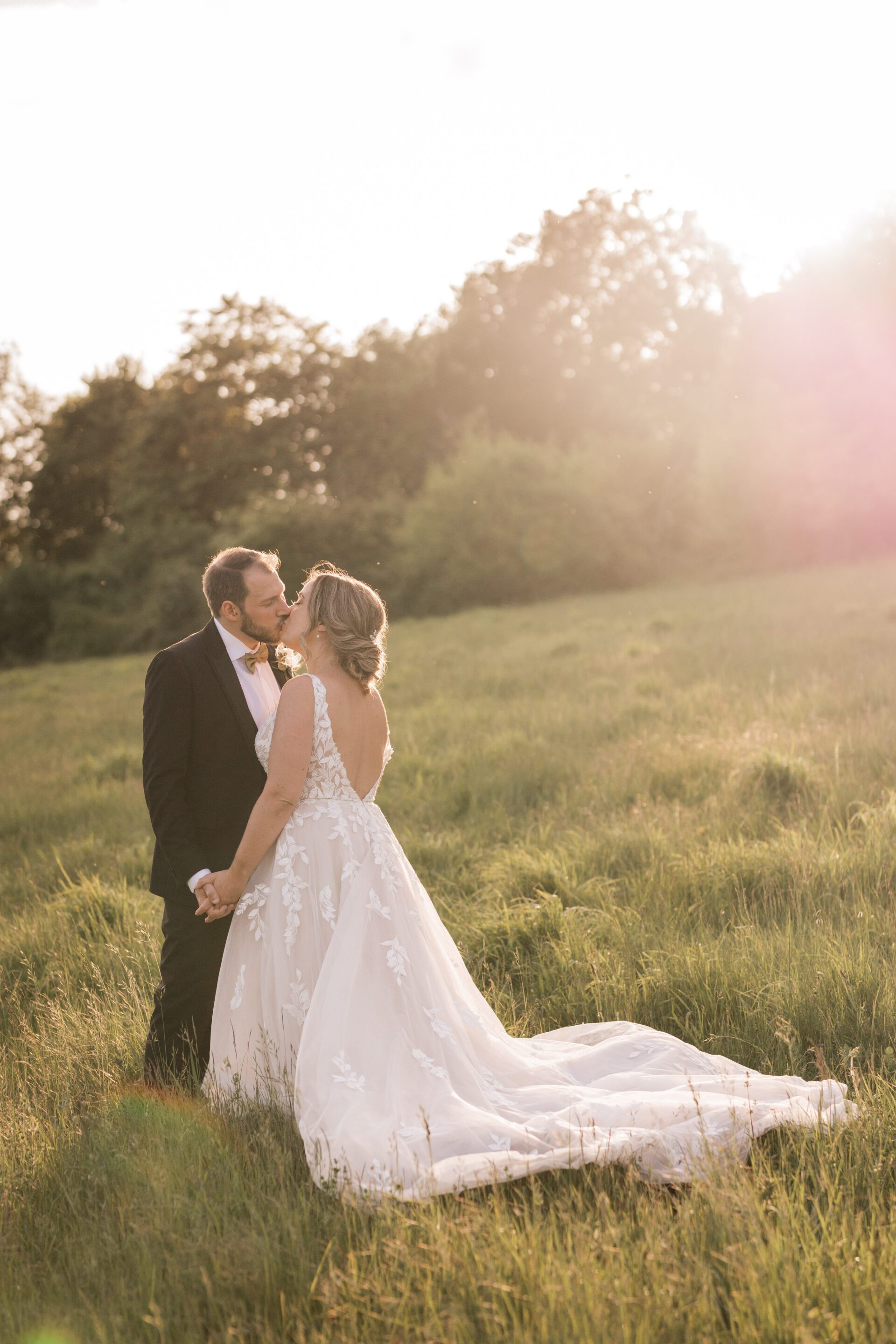The bride and groom share a kiss during a golden hour couple portrait session