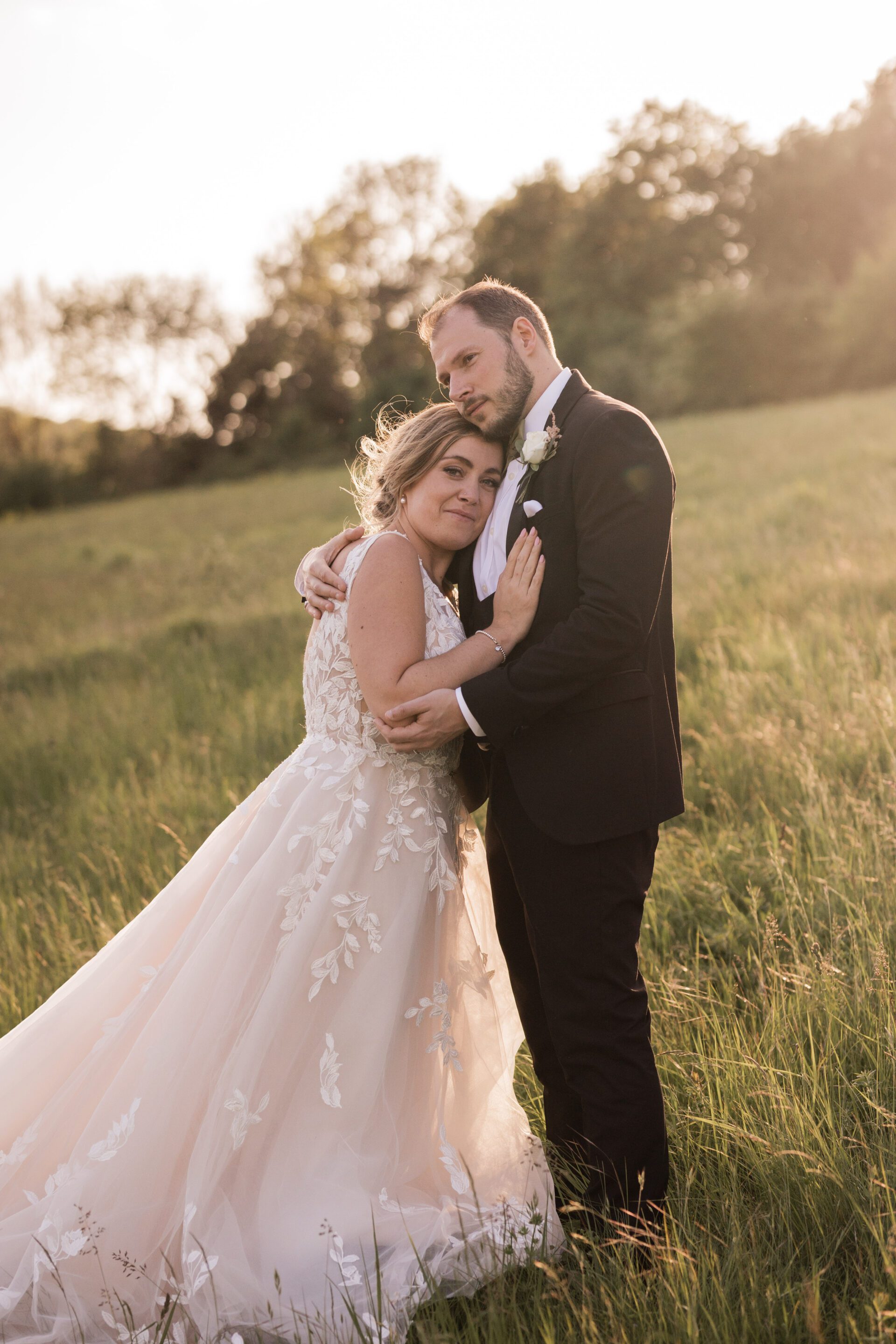 The bride and groom embrace during their couples portraits at golden hour