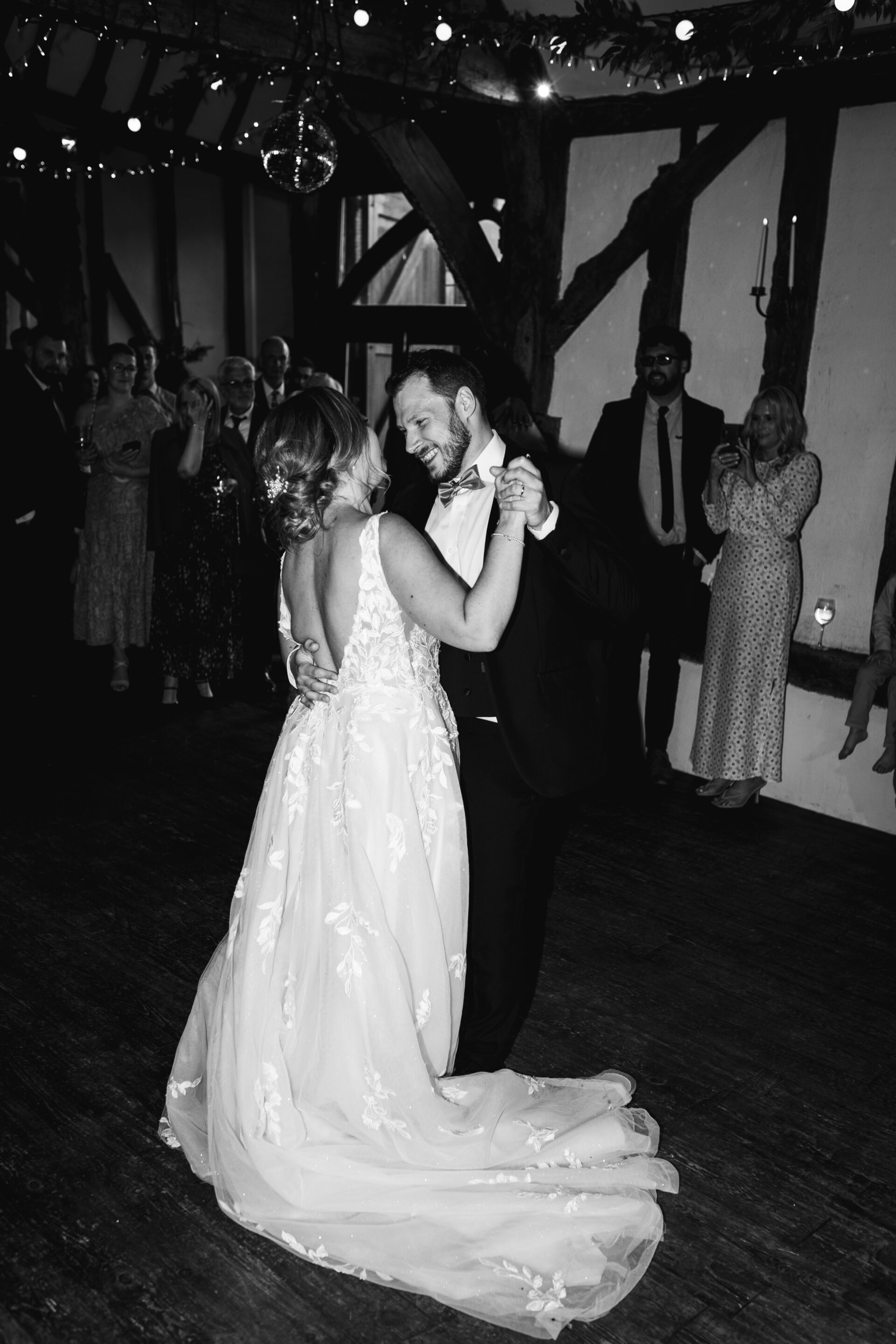 The bride and groom perform their first dance at Old Luxters Barn wedding venue in Oxfordshire