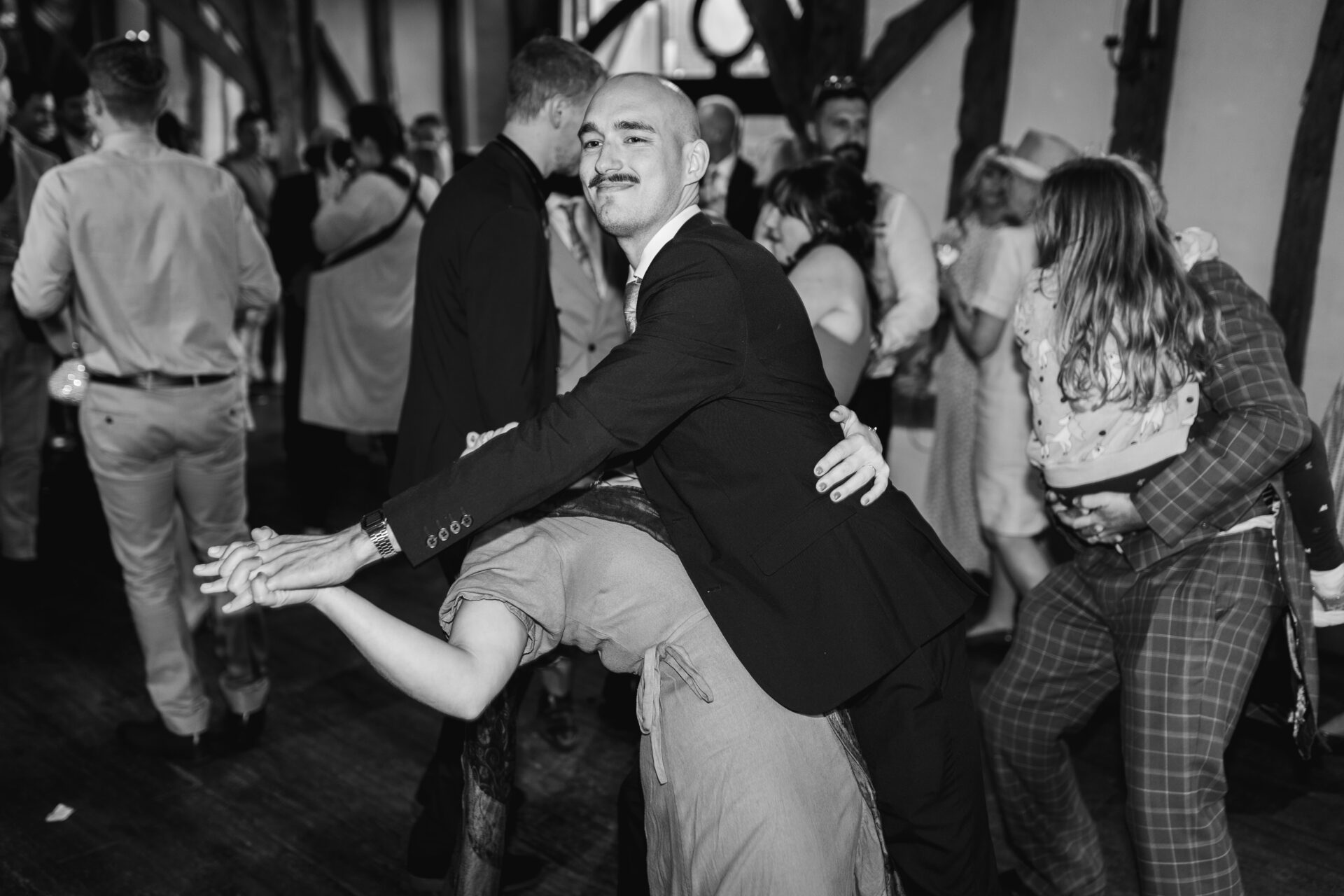 Wedding guests dance at Old Luxters Barn wedding venue in Oxfordshire