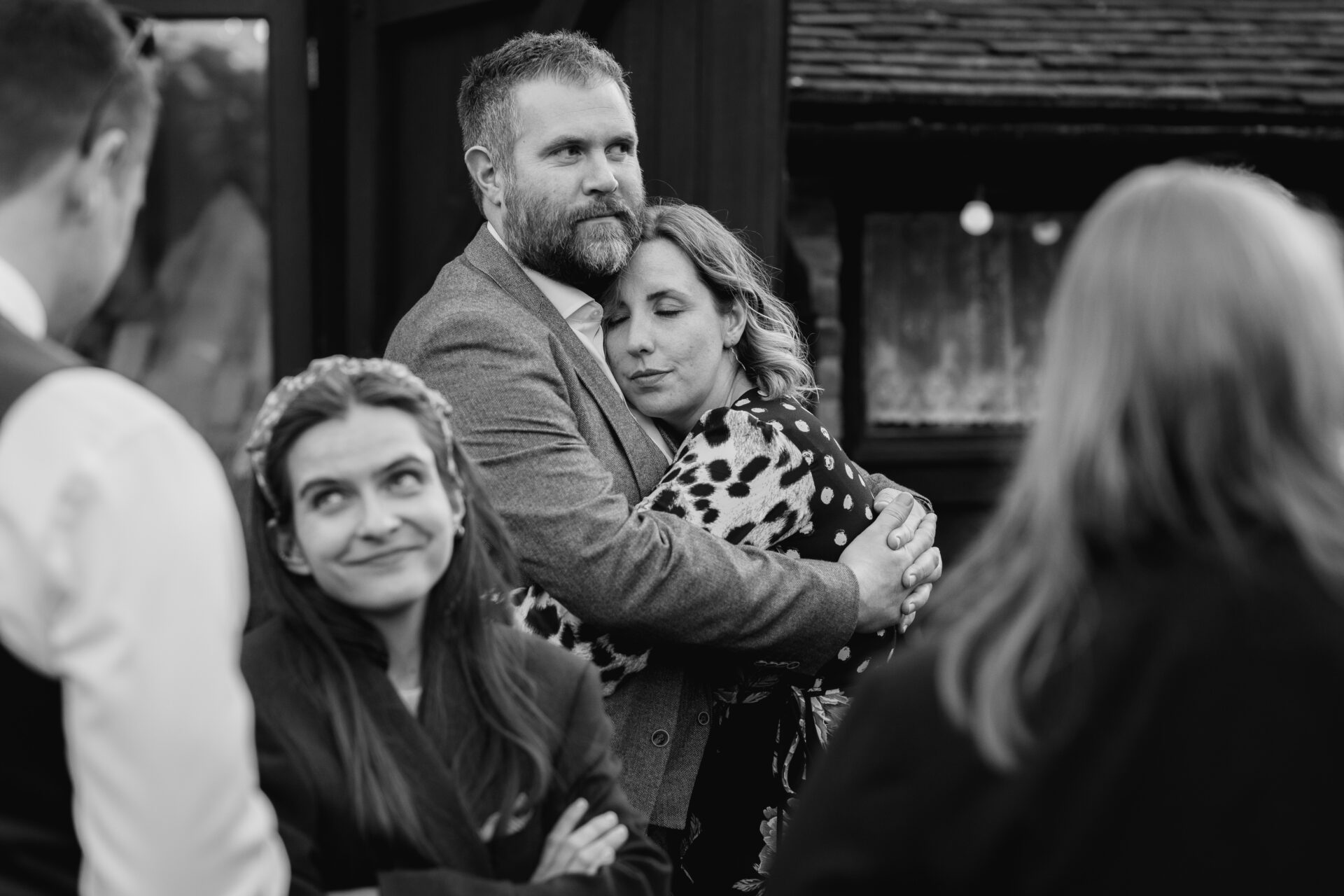 Wedding guests share an embrace at Old Luxters Barn wedding venue in Oxfordshire