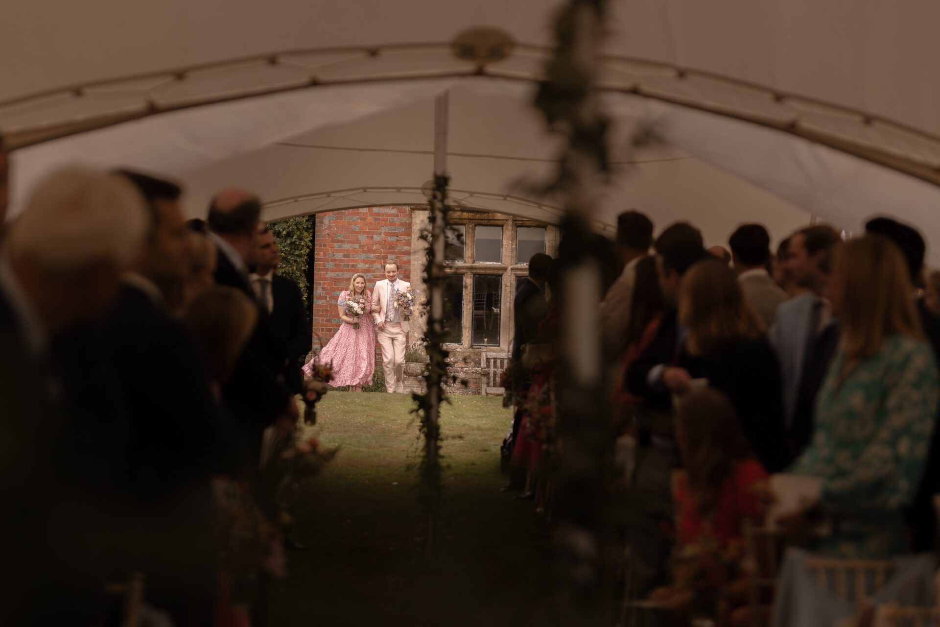 The bridal party join the marquee wedding ceremony at Brickwall House
