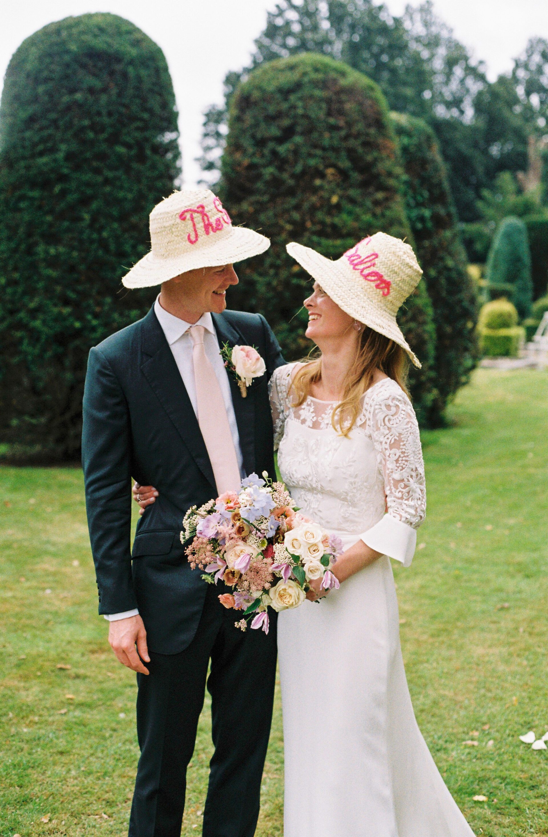 The bride and groom add a fun touch to their wedding with personalised hats