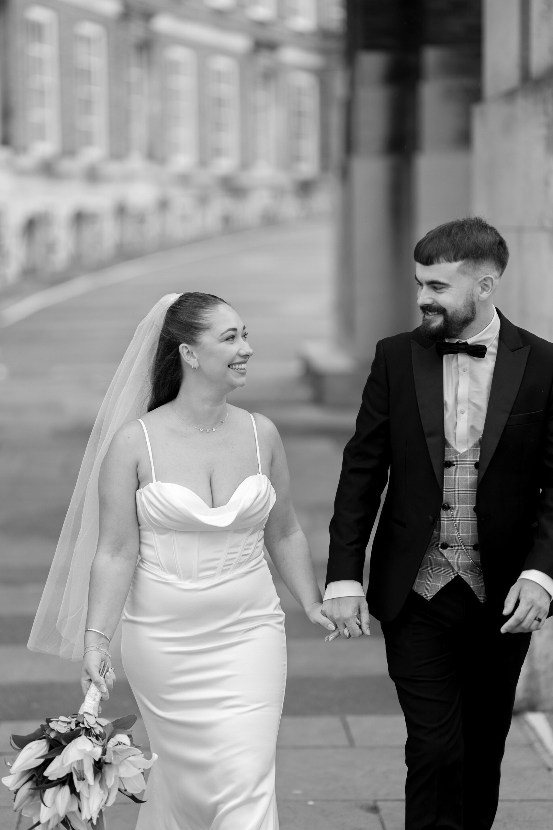 The bride and groom walk hand in hand for couple portraits in Bristol