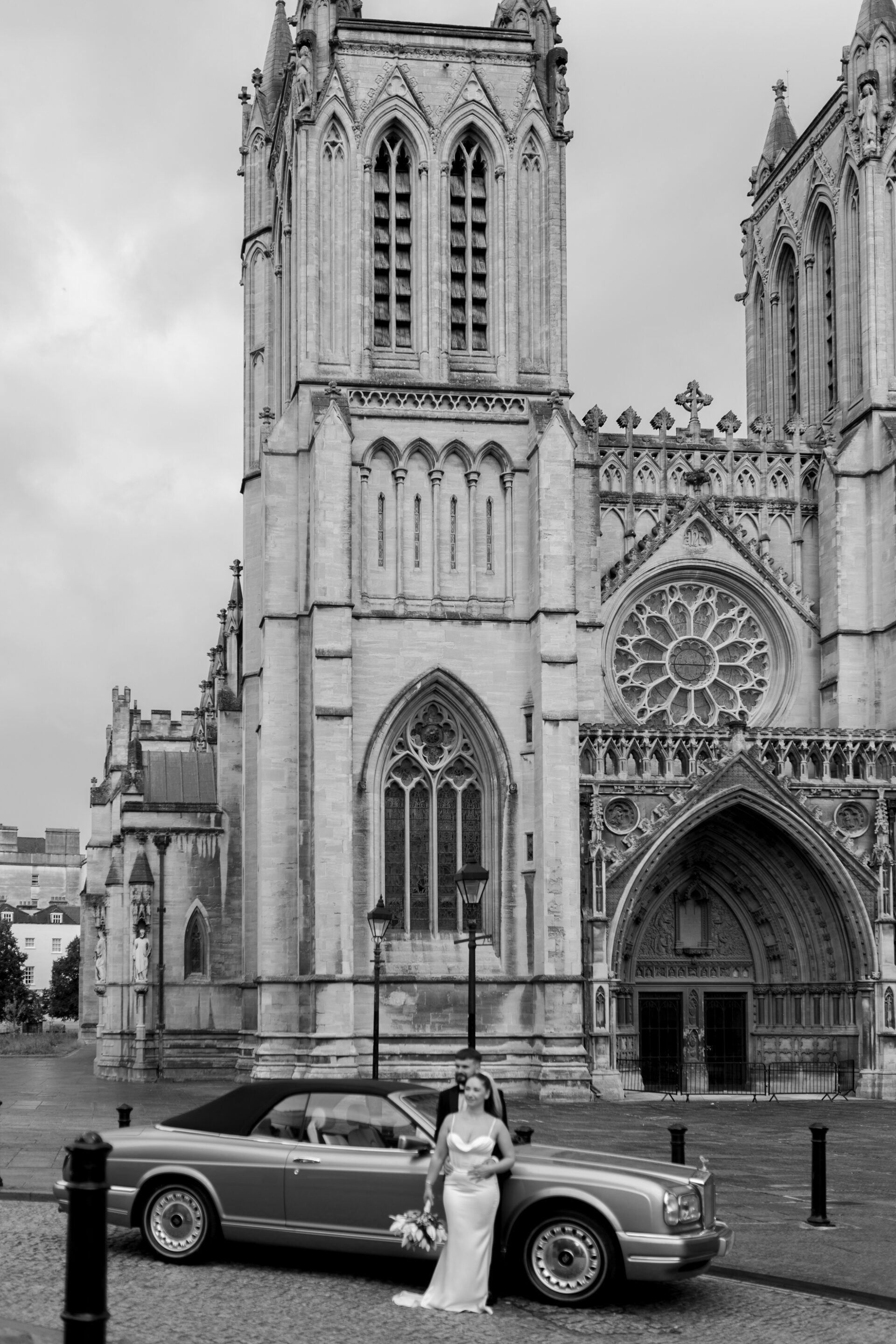 The bride and groom pictured against a backdrop of Bristol Cathedral during our editorial couple portrait session