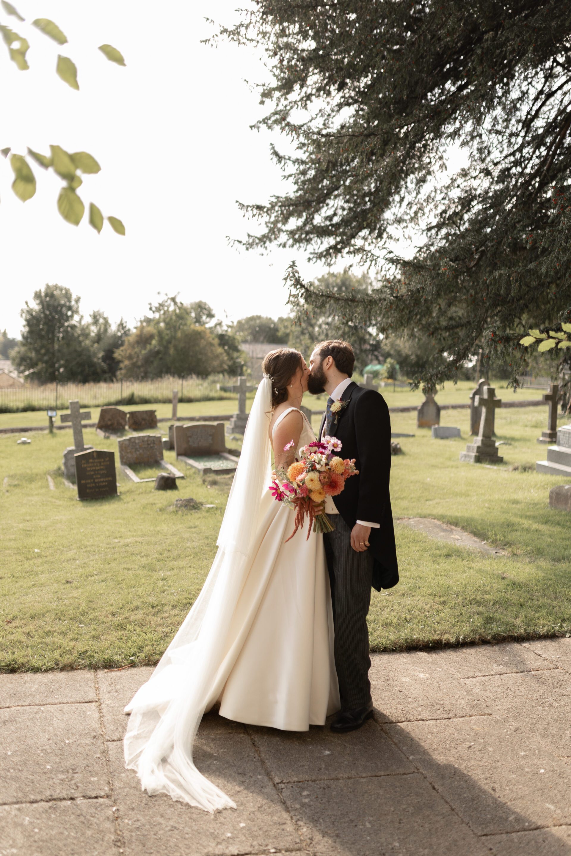 The bride and groom share a kiss after their Somerset church wedding ceremony