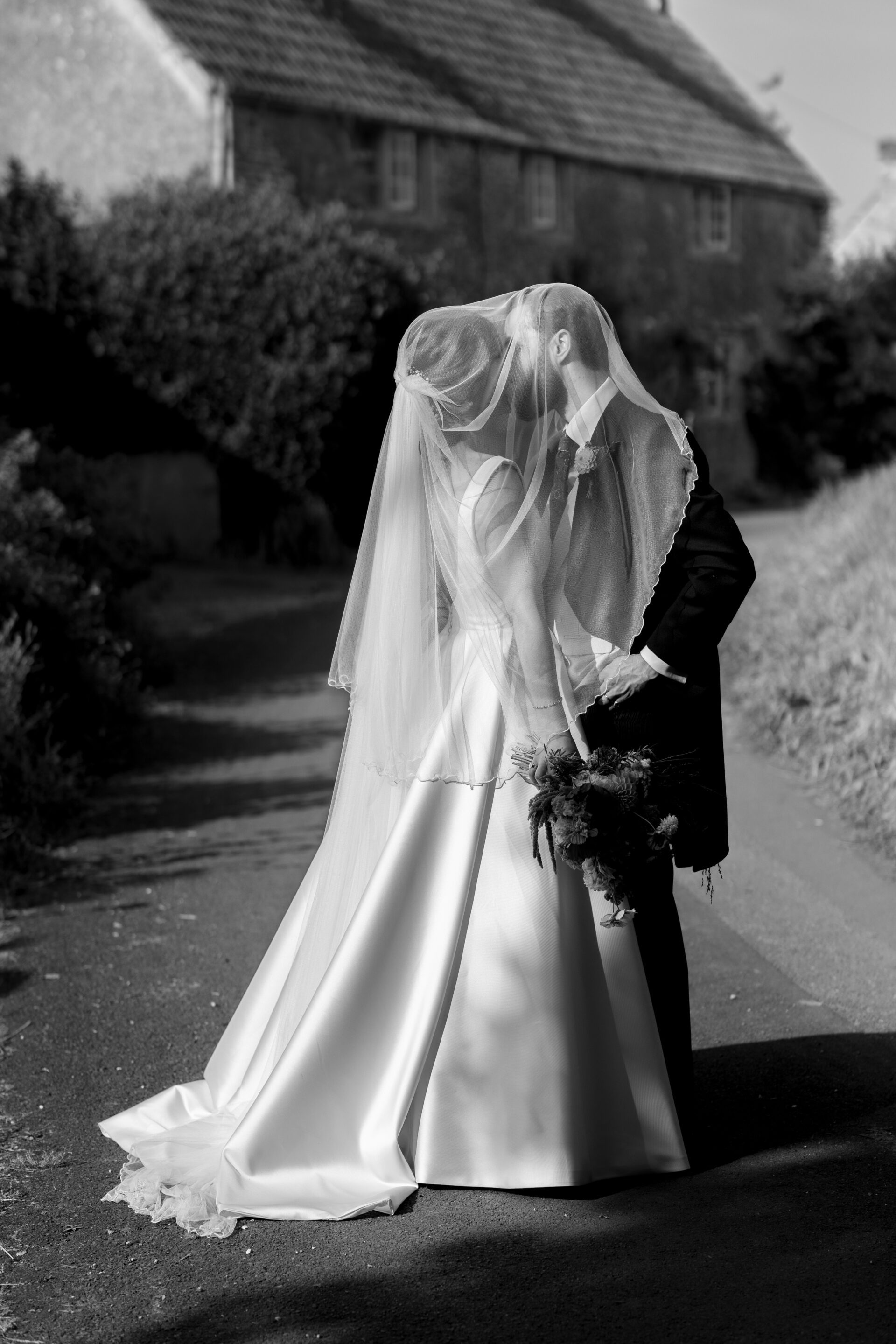 The bride and groom kiss under the veil