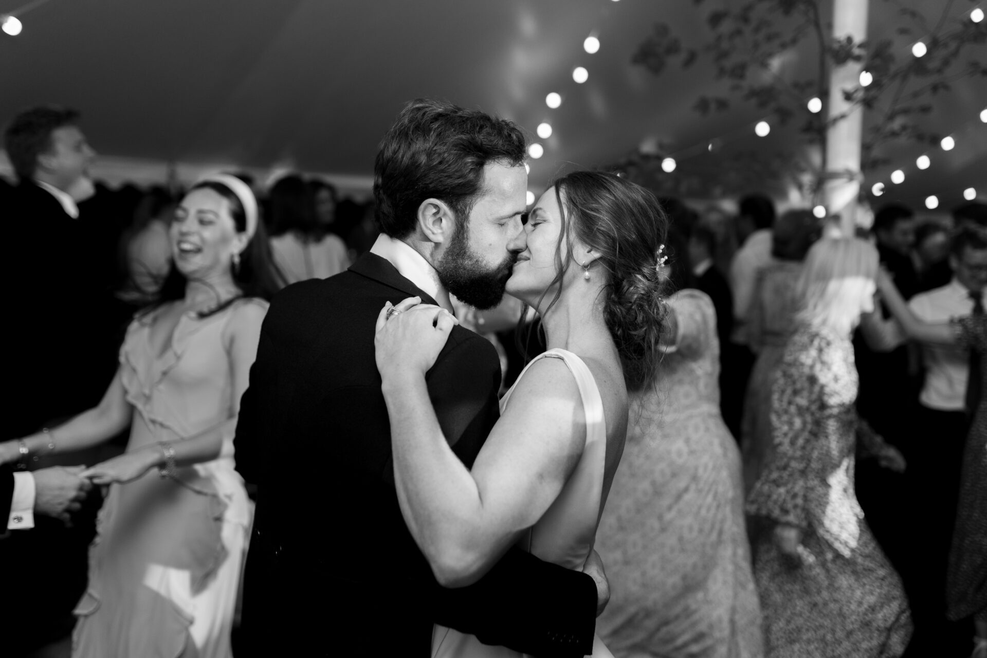 The bride and groom share a kiss on the dance floor at their Somerset marquee wedding