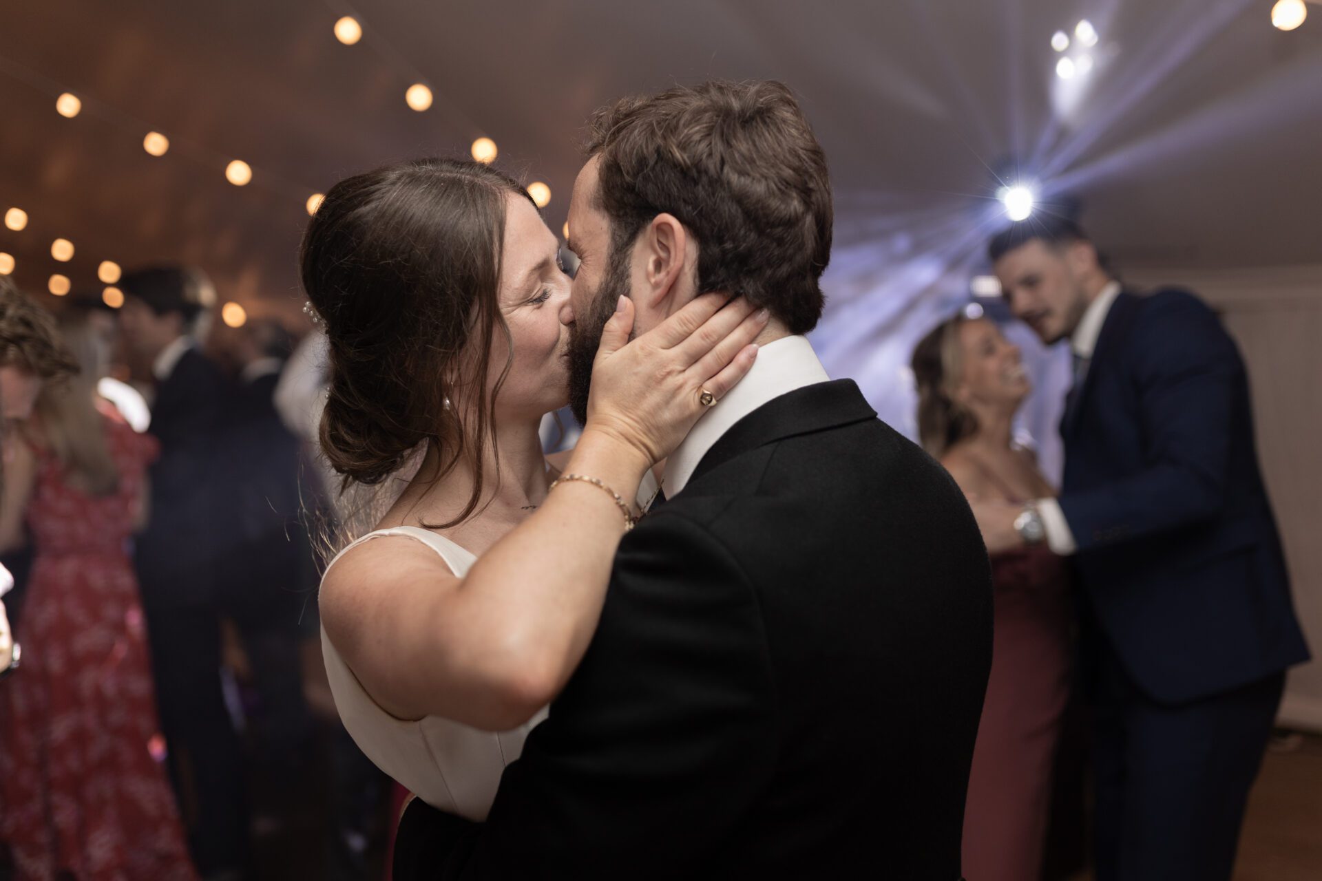 The bride and groom share a kiss on the dance floor