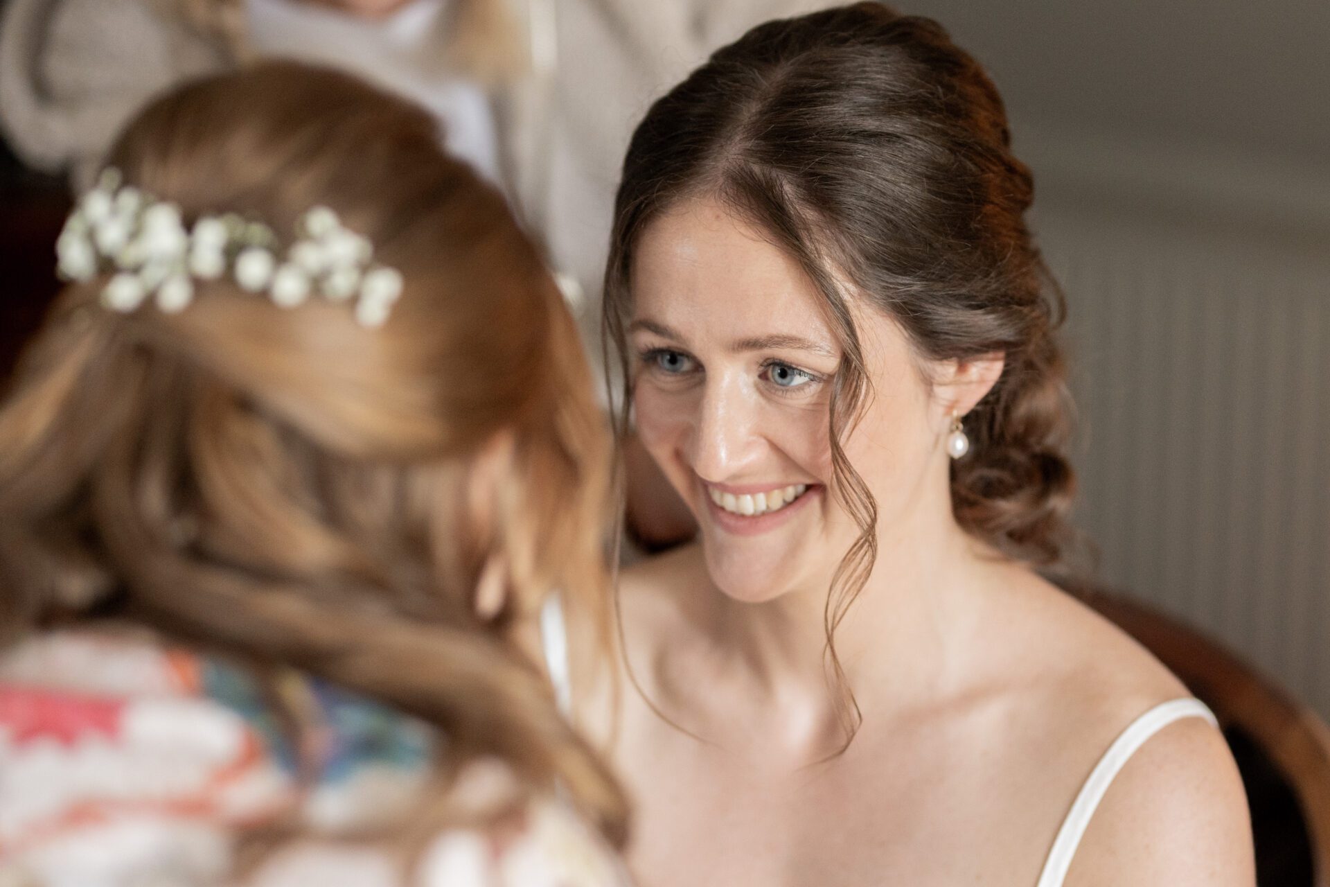 The bride shares a moment with a bridesmaid before her Somerset wedding