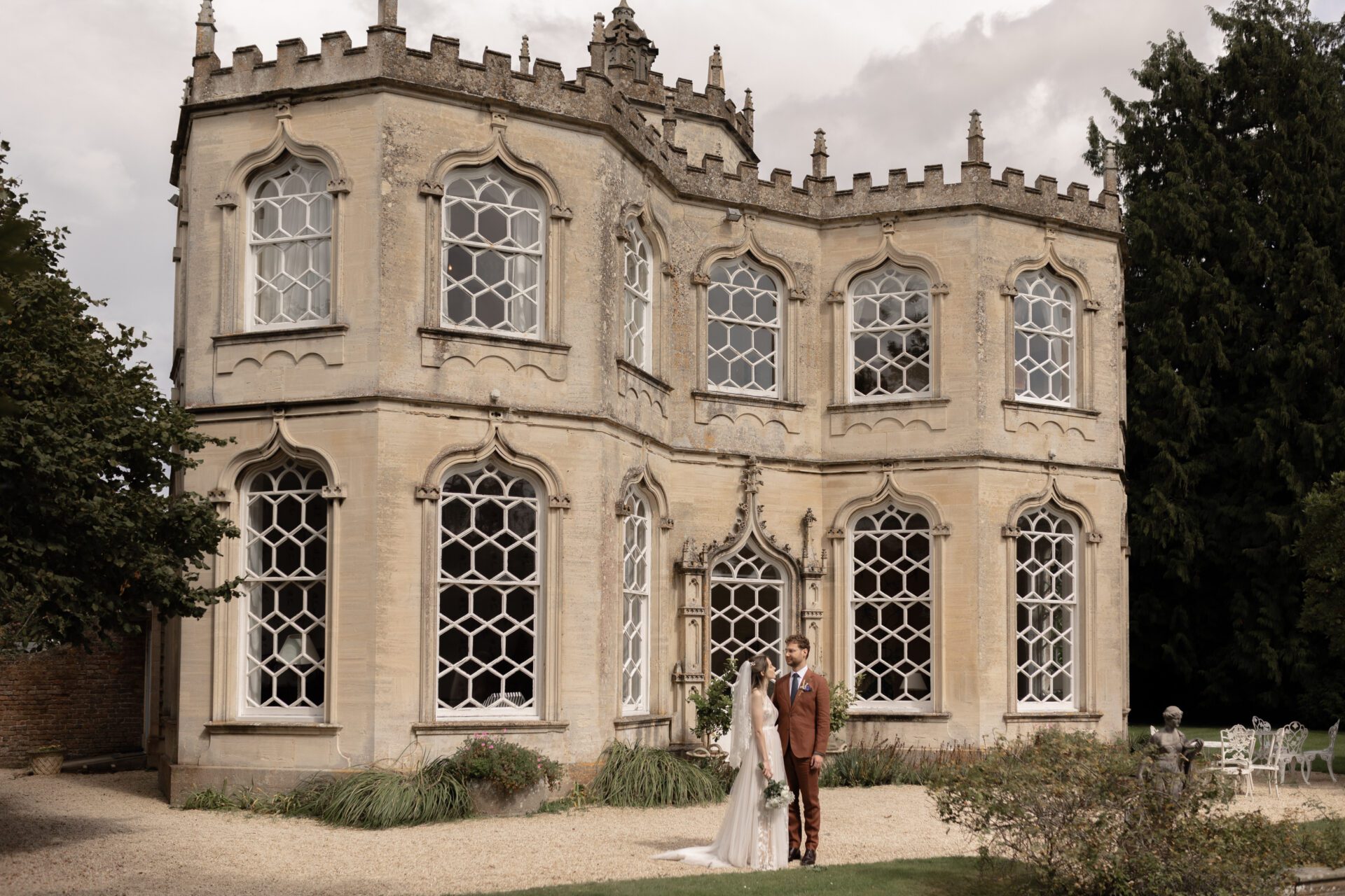 The bride and groom pause in front of the Orangery at Frampton Court Estate, Gloucestershire wedding venue