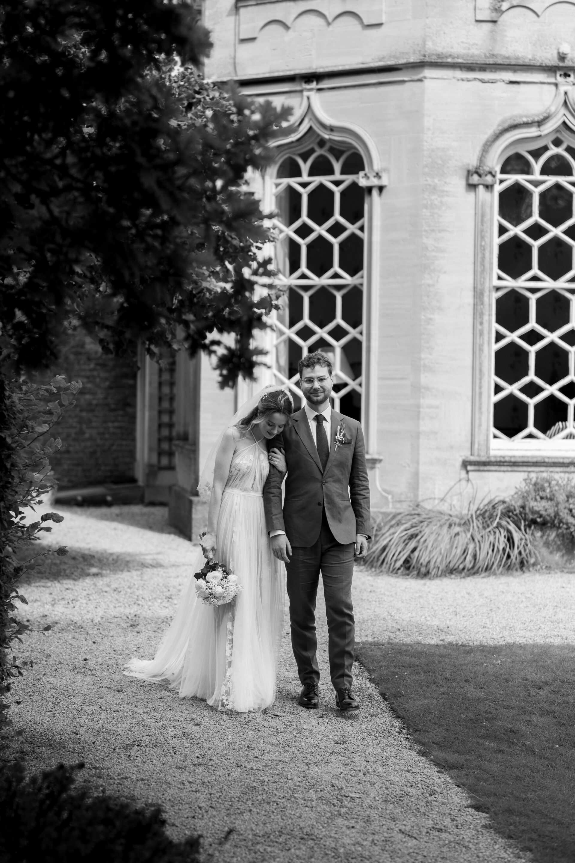 The bride and groom walk arm in arm at Frampton Court Estate, Gloucestershire wedding venue