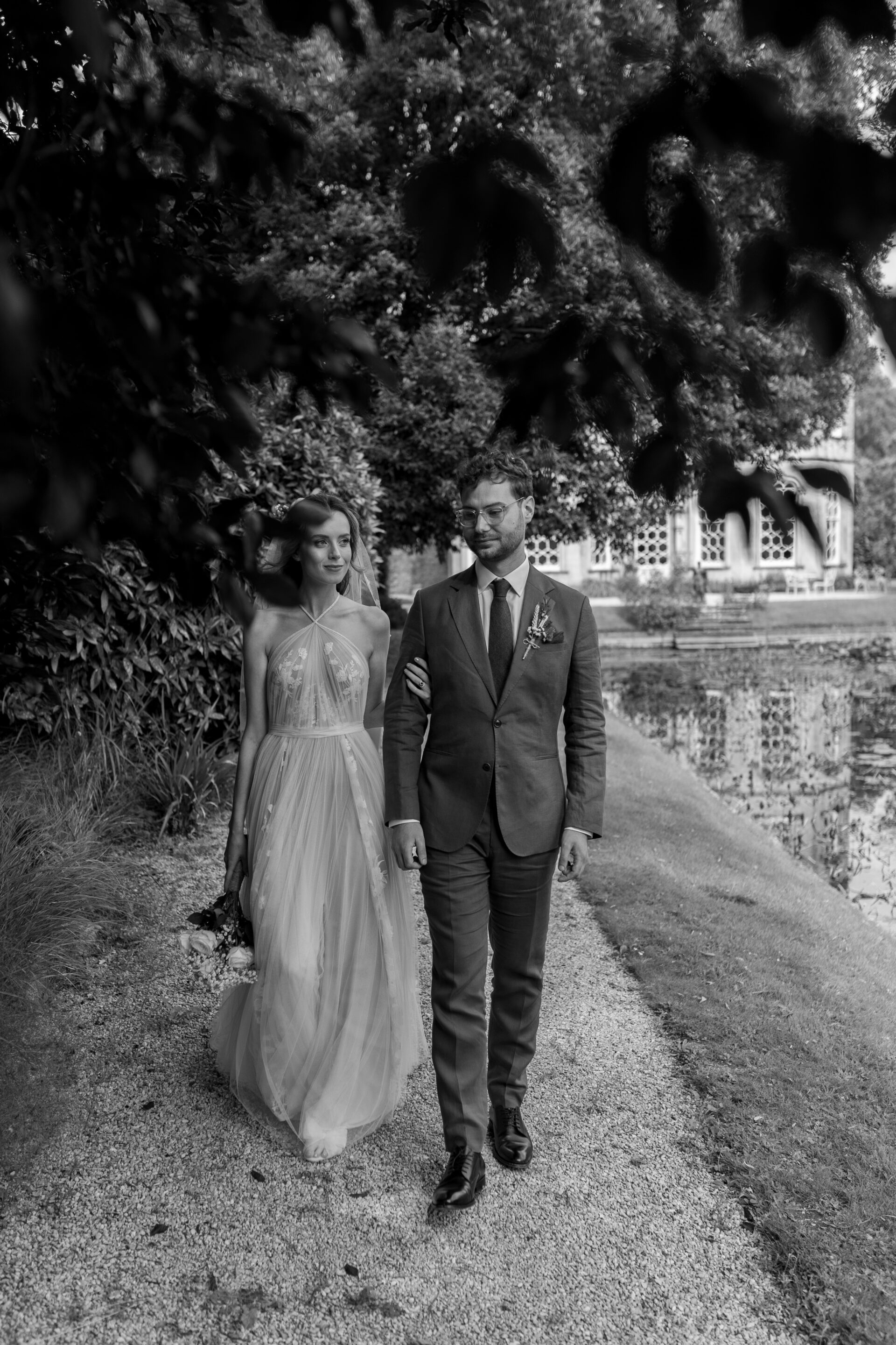 The bride and groom explore the grounds at Frampton Court Estate, Gloucestershire wedding venue