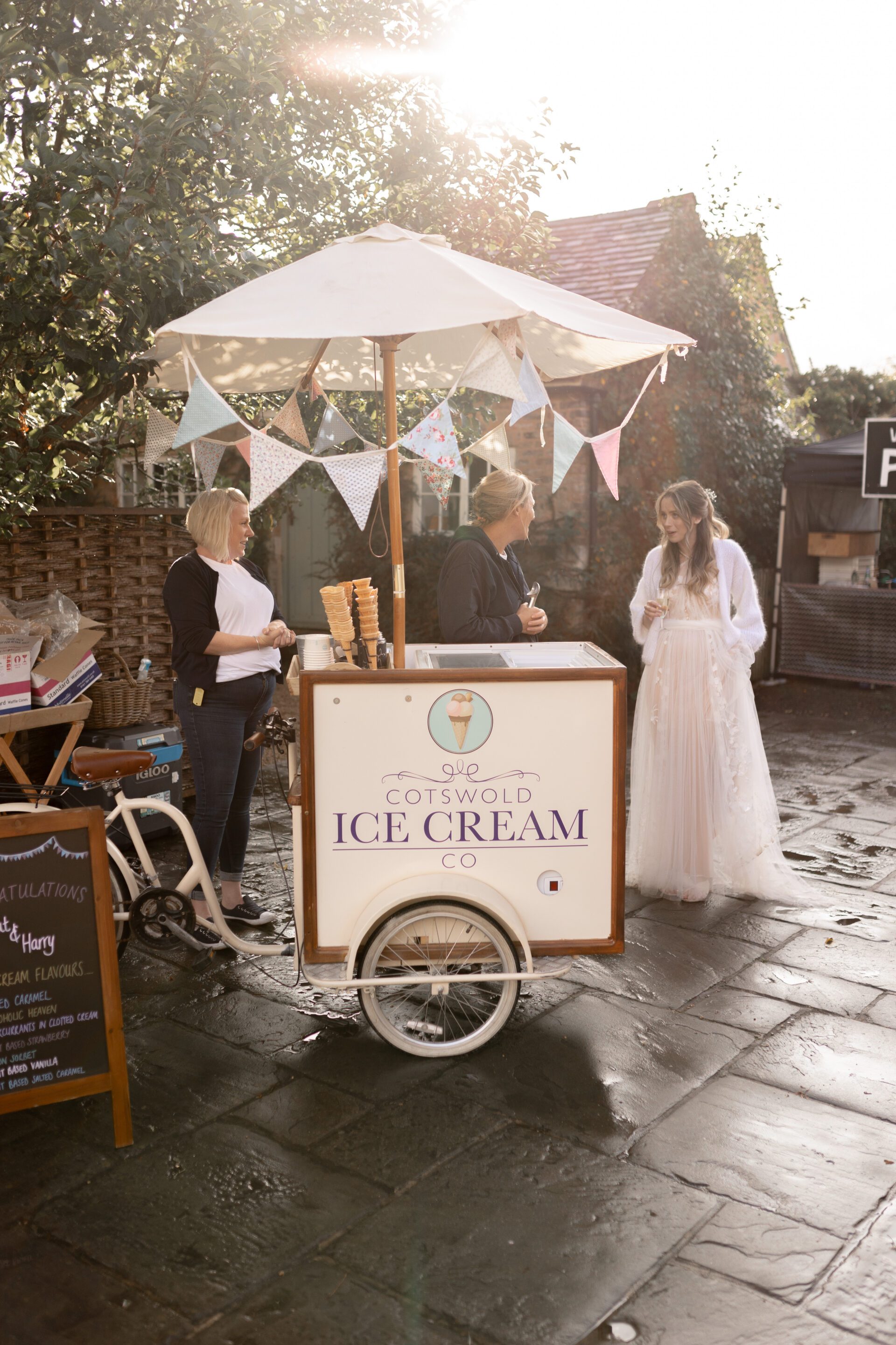 The bride enjoys an ice cream from Cotswold Ice Cream Company at the Wool Barn, Gloucestershire wedding venue in Frampton