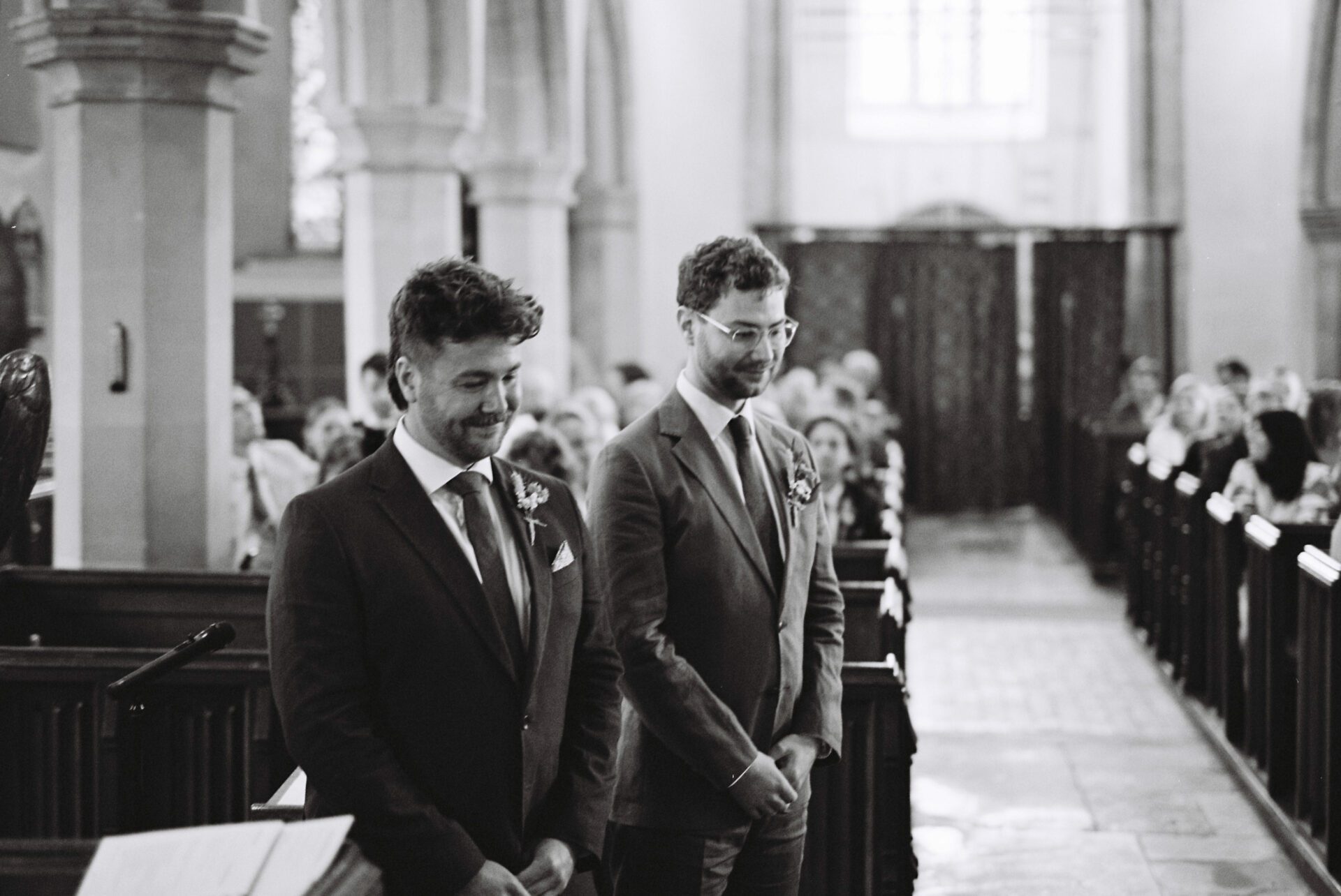 The groom awaits the arrival of the bride at his Gloucestershire church wedding, captured on 35mm film