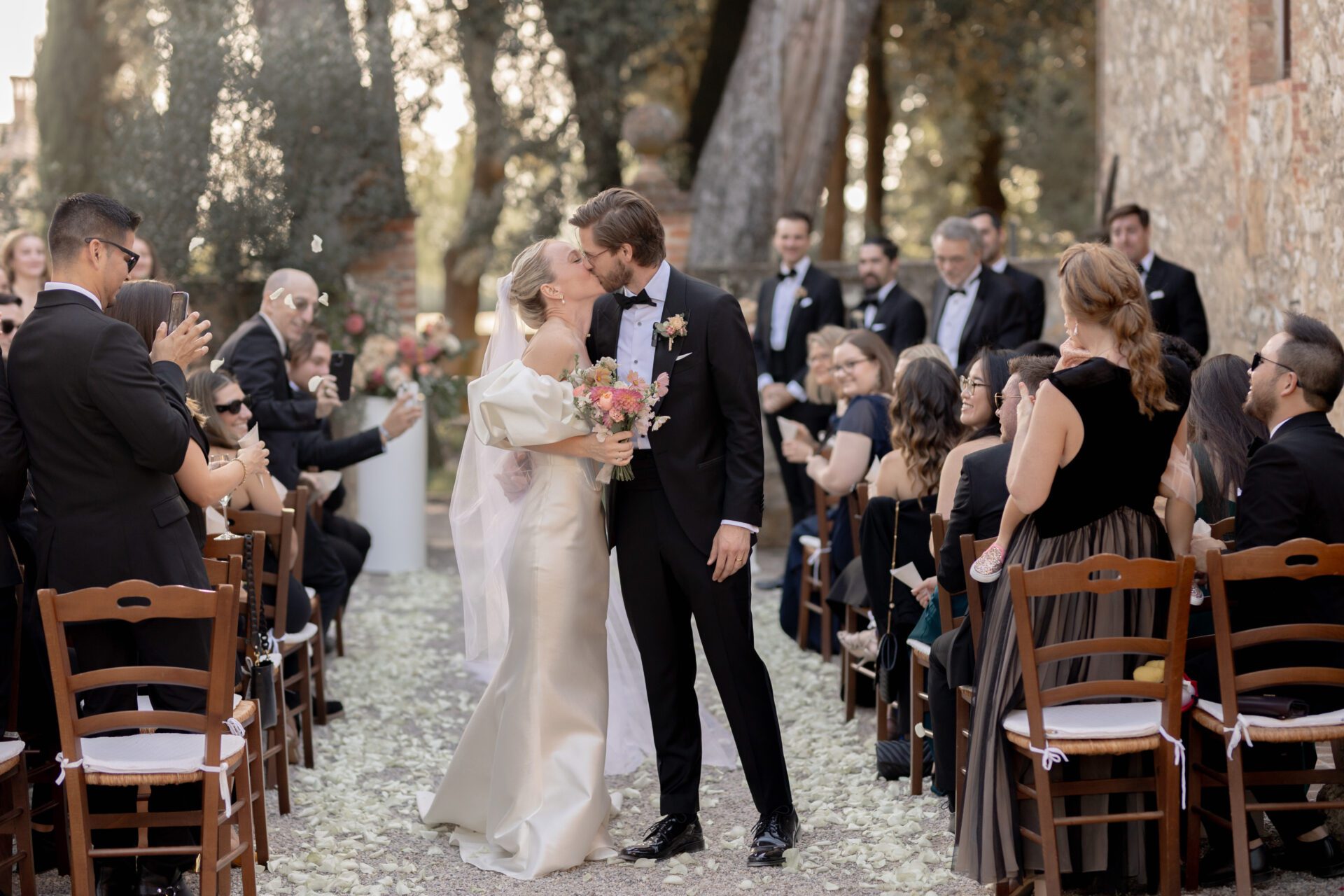 Italian wedding photography captures confetti tunnel at Tuscan wedding ceremony