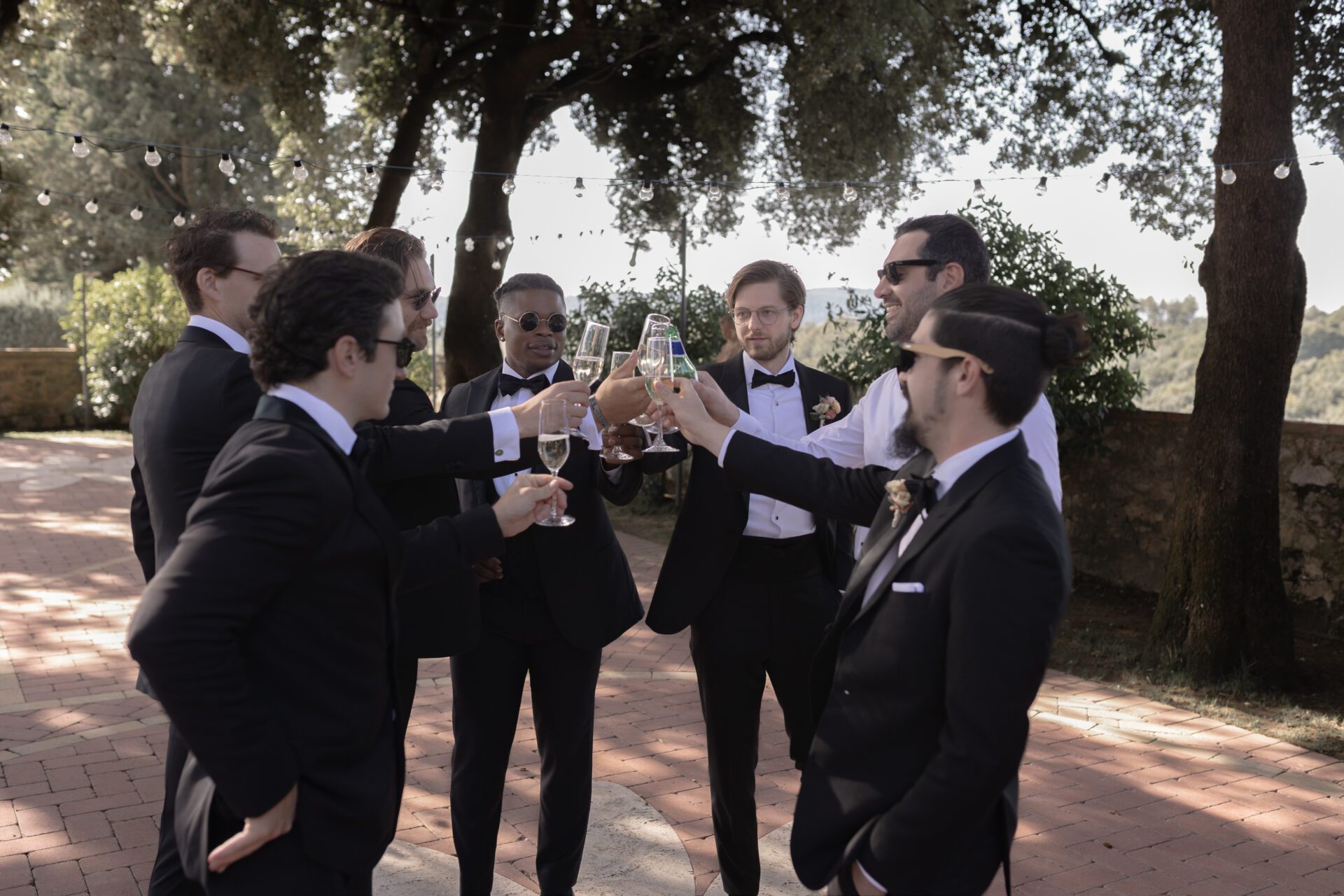 The groom and his groomsmen share a drink at his wedding in Tuscany