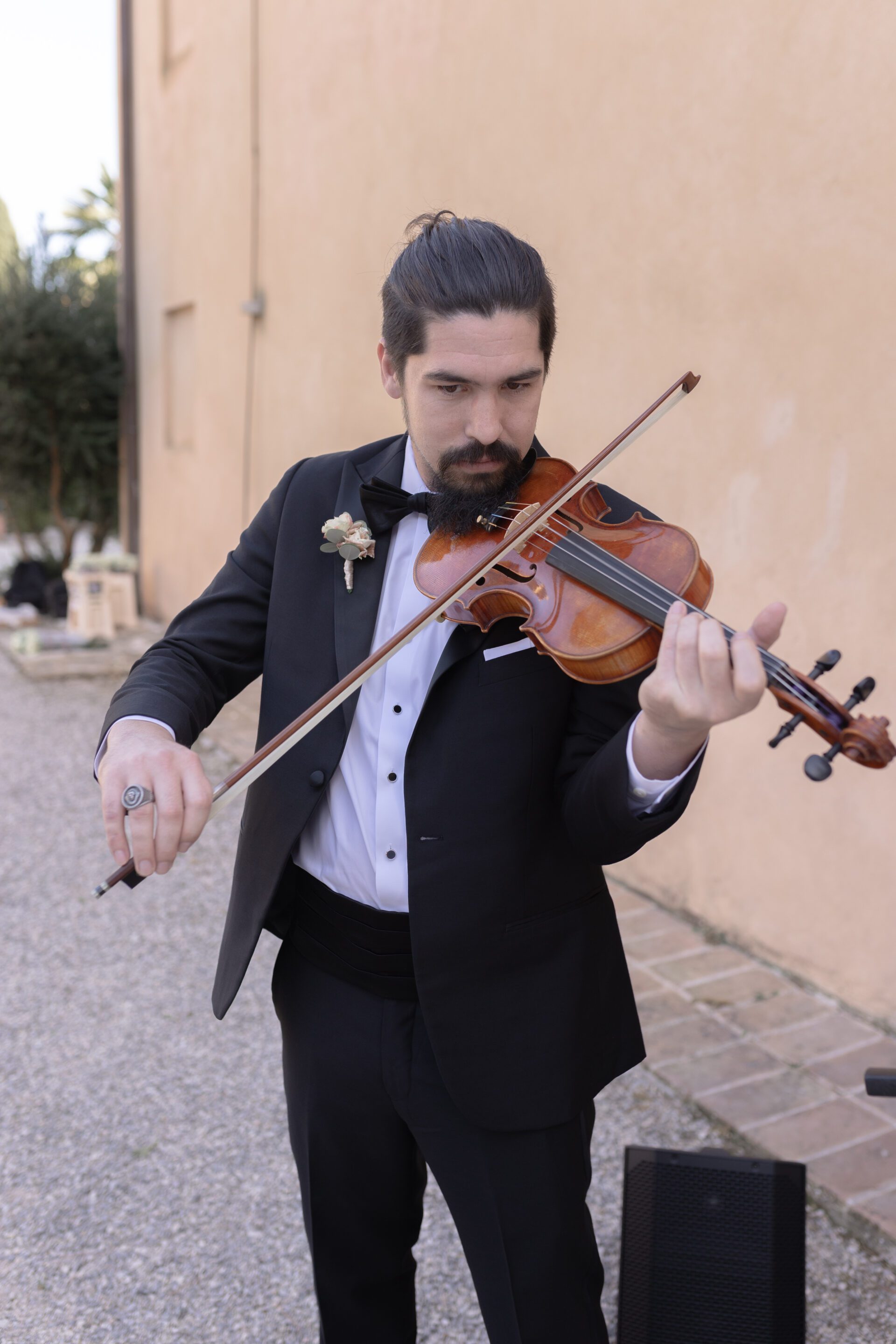 The groomsman plays the violin during the Italian wedding ceremony
