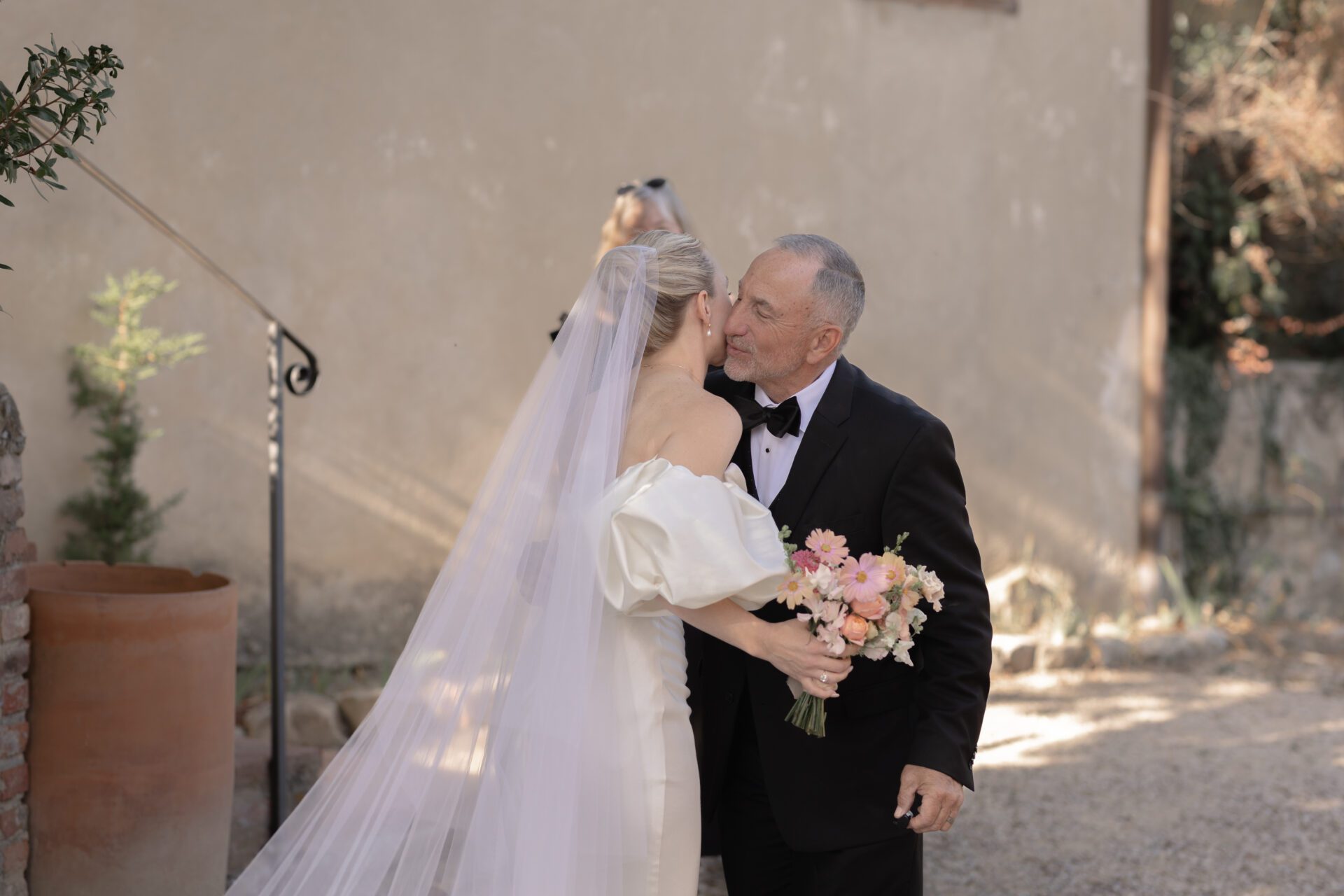 The bride shares an embrace with her father at her Tuscan wedding